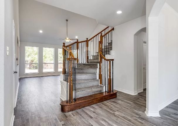 Interior view of a home foyer featuring a wooden staircase and wood-look flooring.