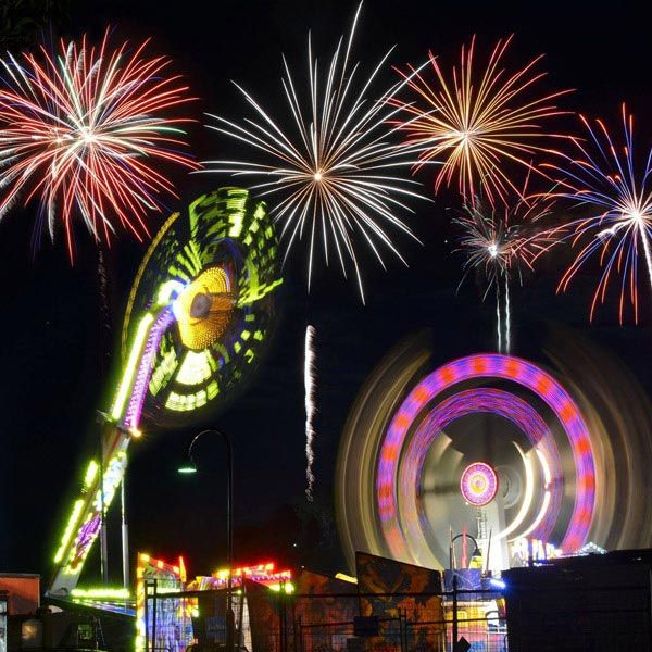 fireworks display over fair ground rides