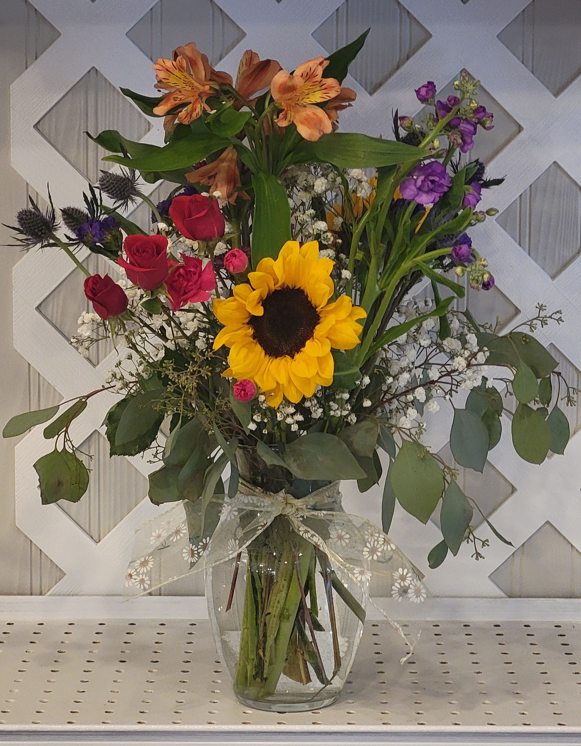 A vase filled with pink flowers is sitting on a table.