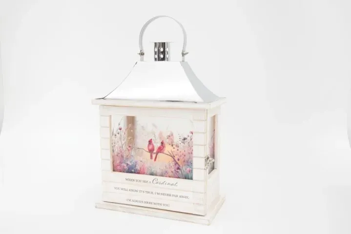 A white lantern with a picture of birds and flowers on it.