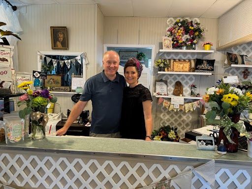 A man and a woman are standing in front of a counter in a store.