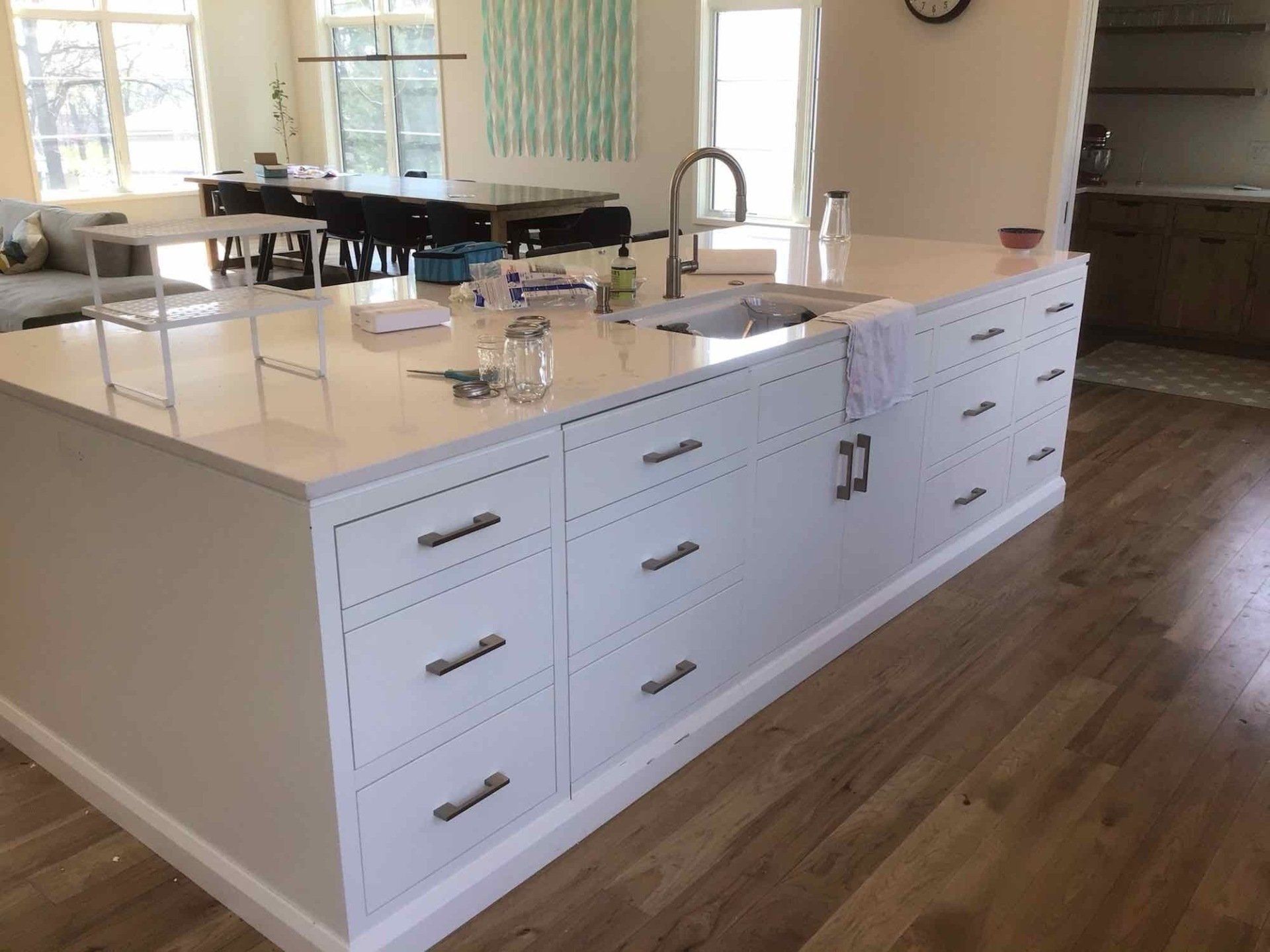 A beautiful kitchen with white cabinets and a large island in the middle.