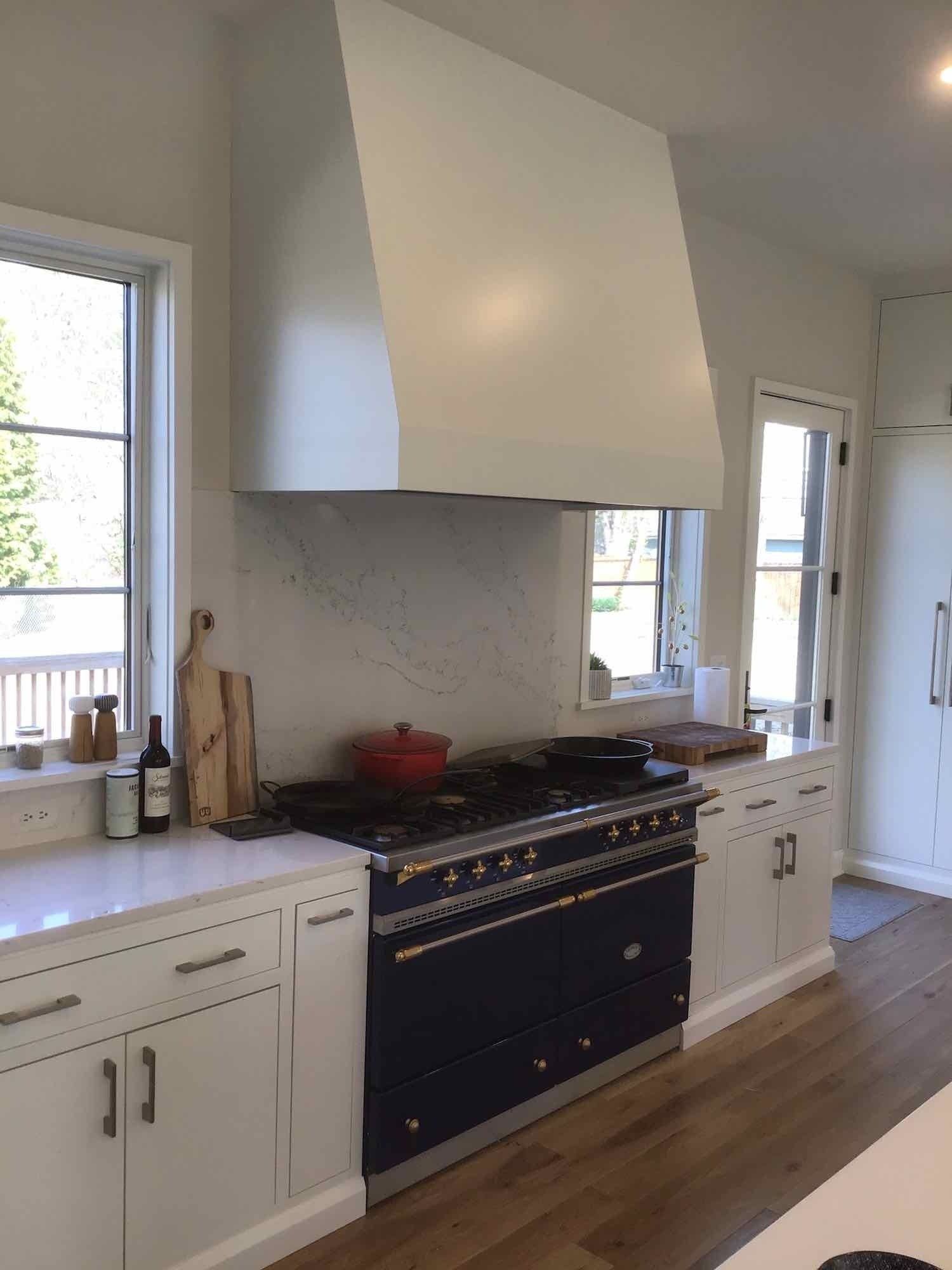 A kitchen with a black stove top oven and white cabinets.