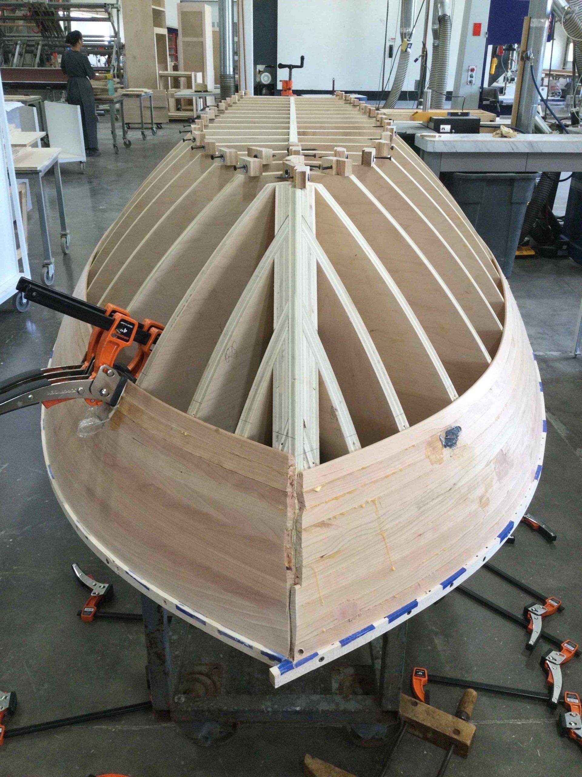 A wooden boat is being built in a workshop