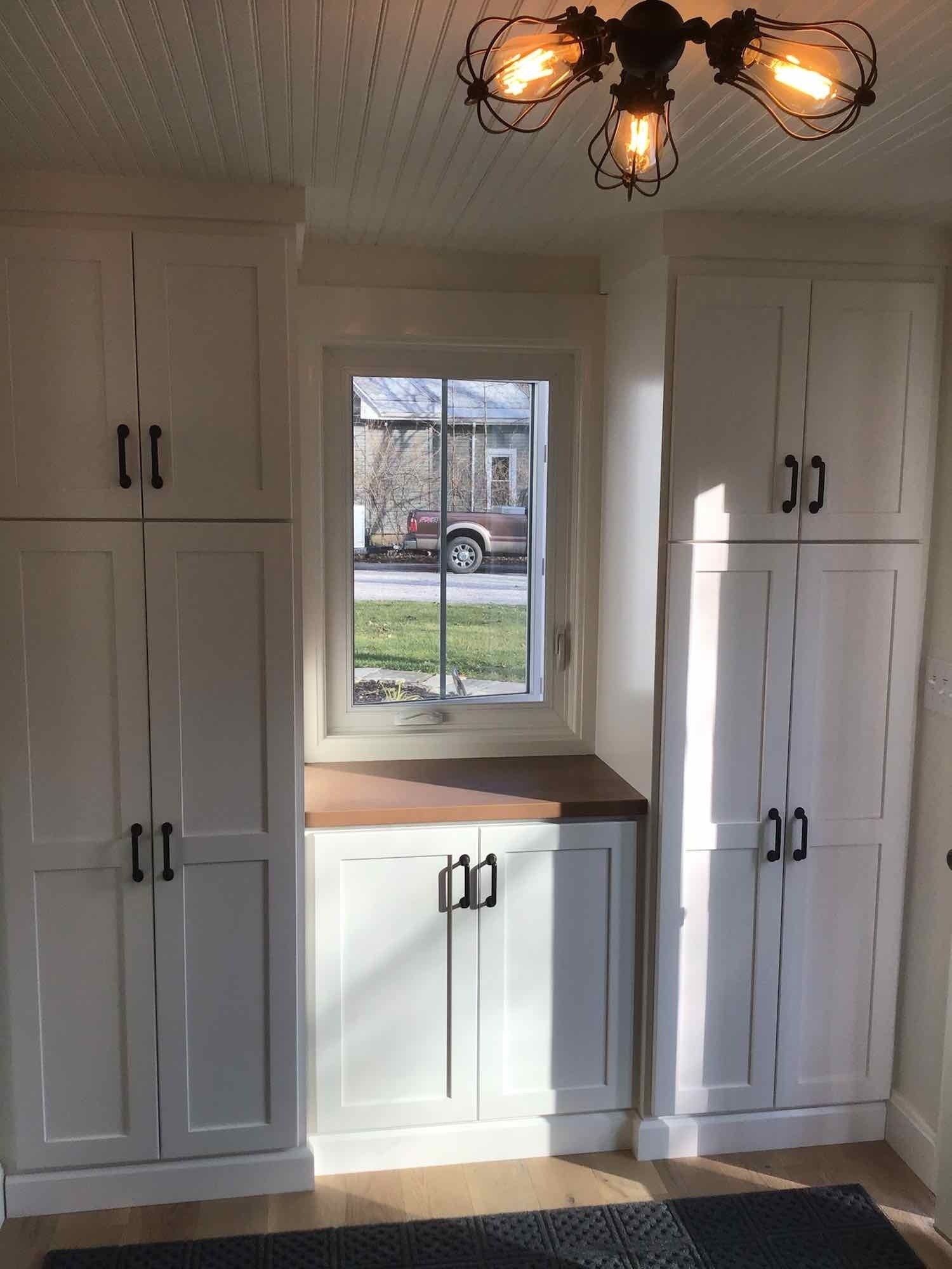 A room with white cabinets and a window.