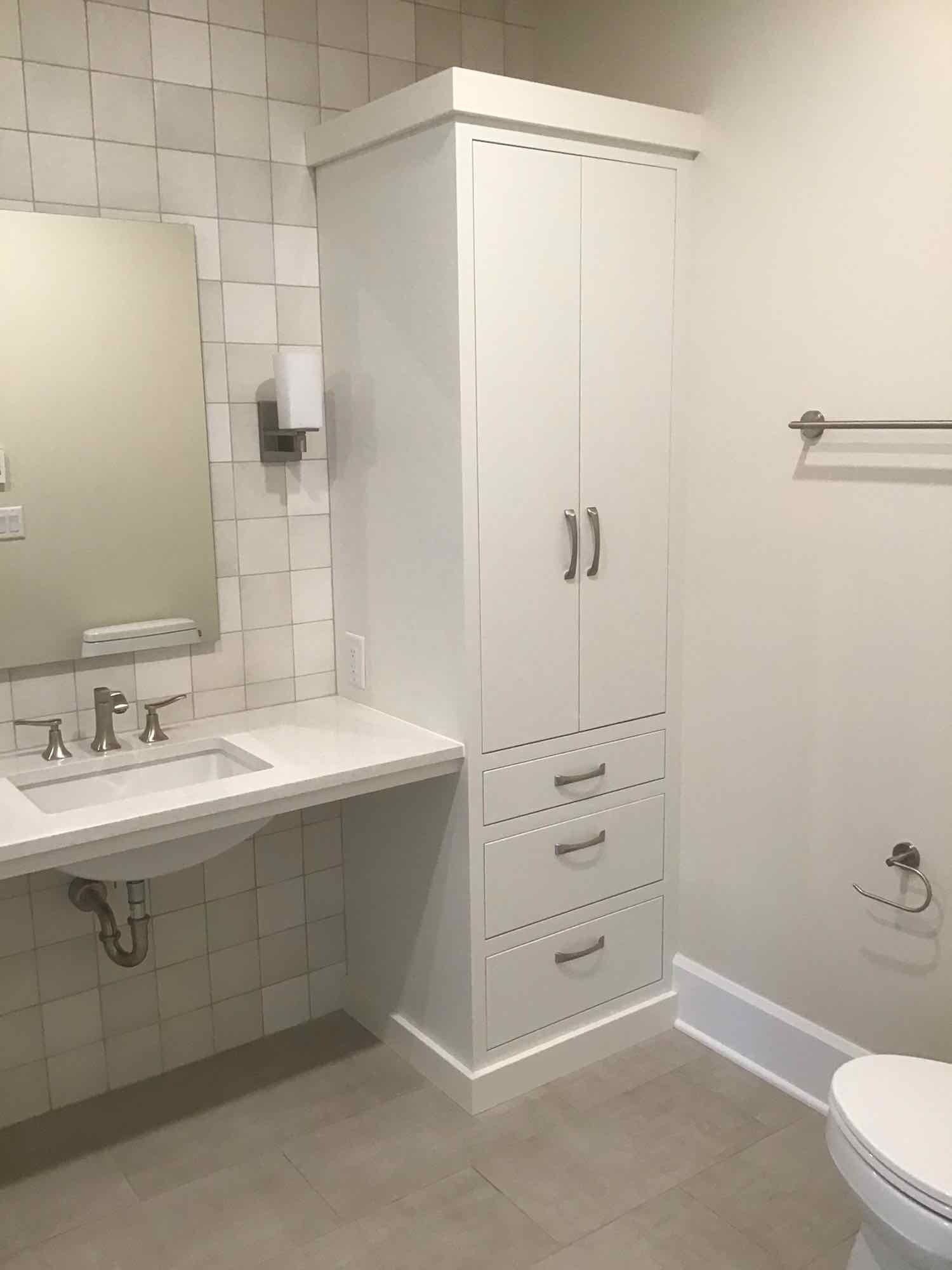 A bathroom with a sink , toilet , mirror and cabinet.