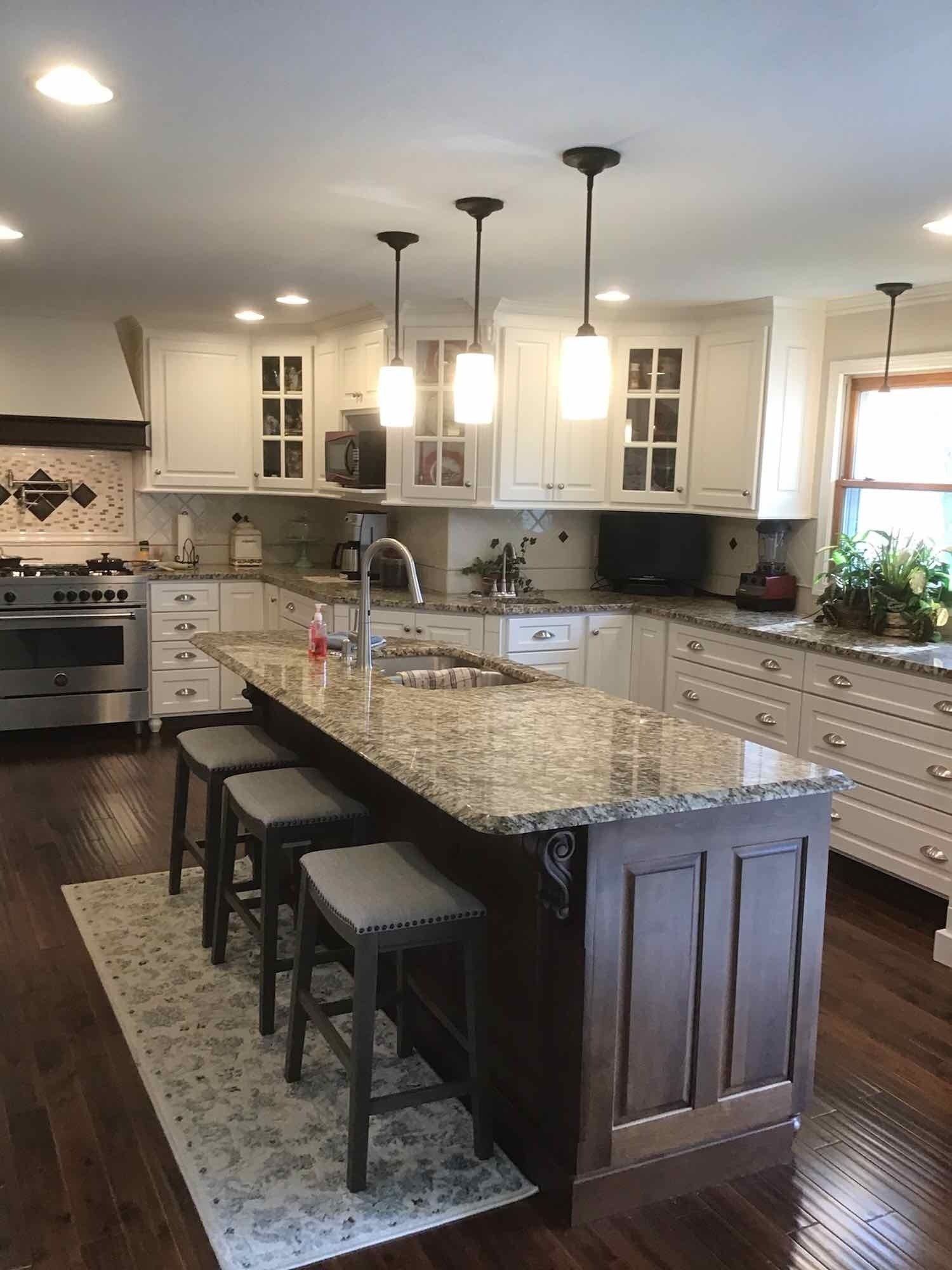 A kitchen with a large island and stools.