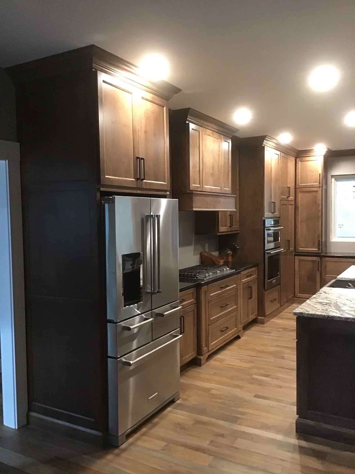 A kitchen with stainless steel appliances and wooden cabinets.