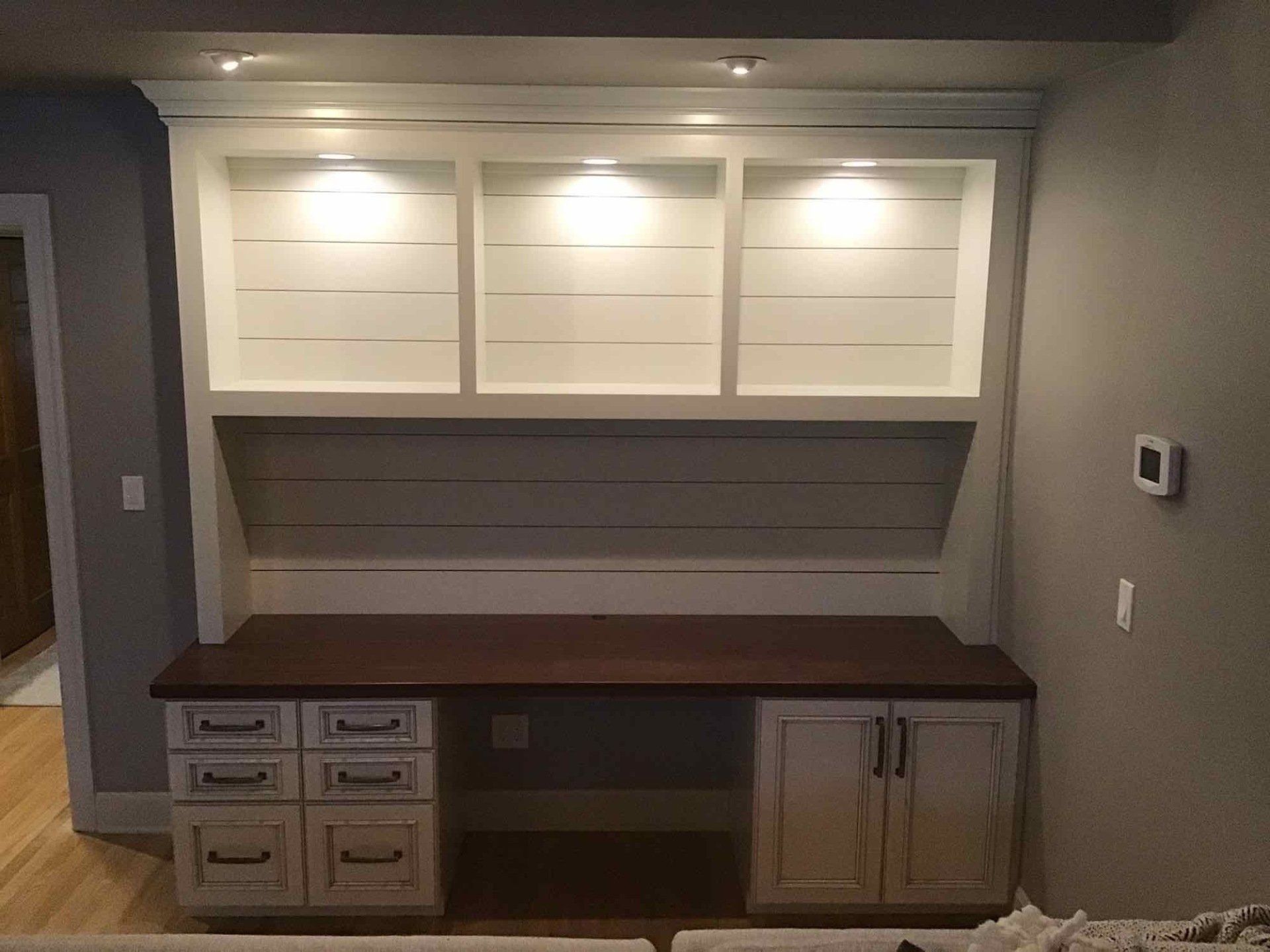 A desk with drawers and shelves in a living room.