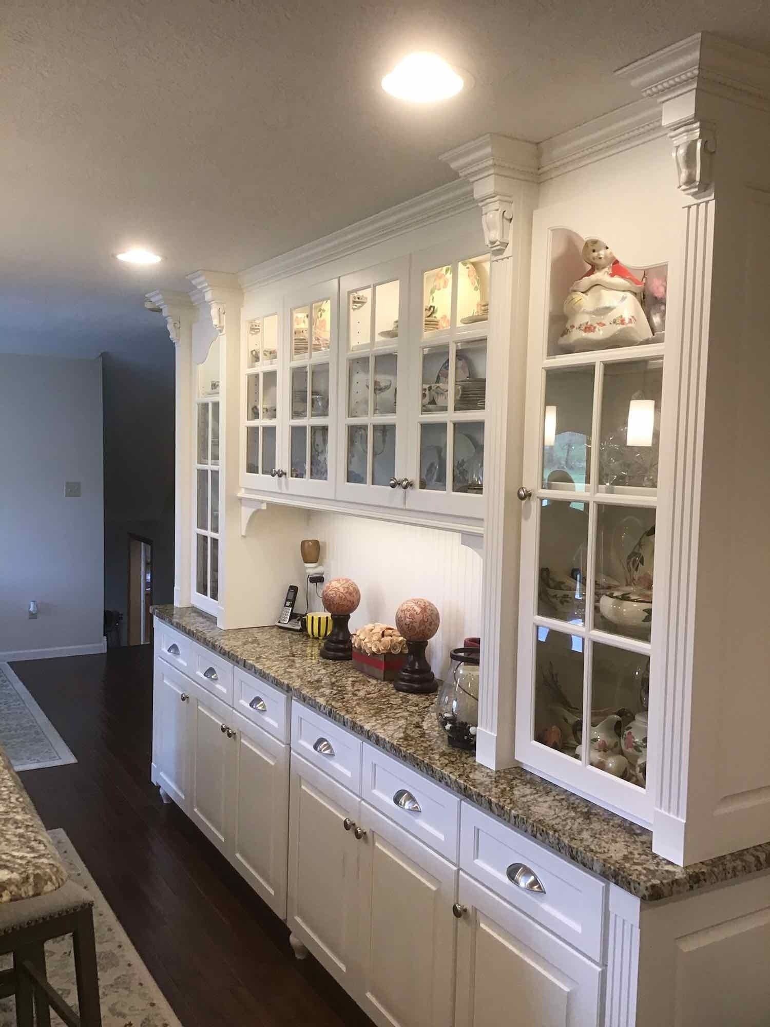 A kitchen with white cabinets and granite counter tops.