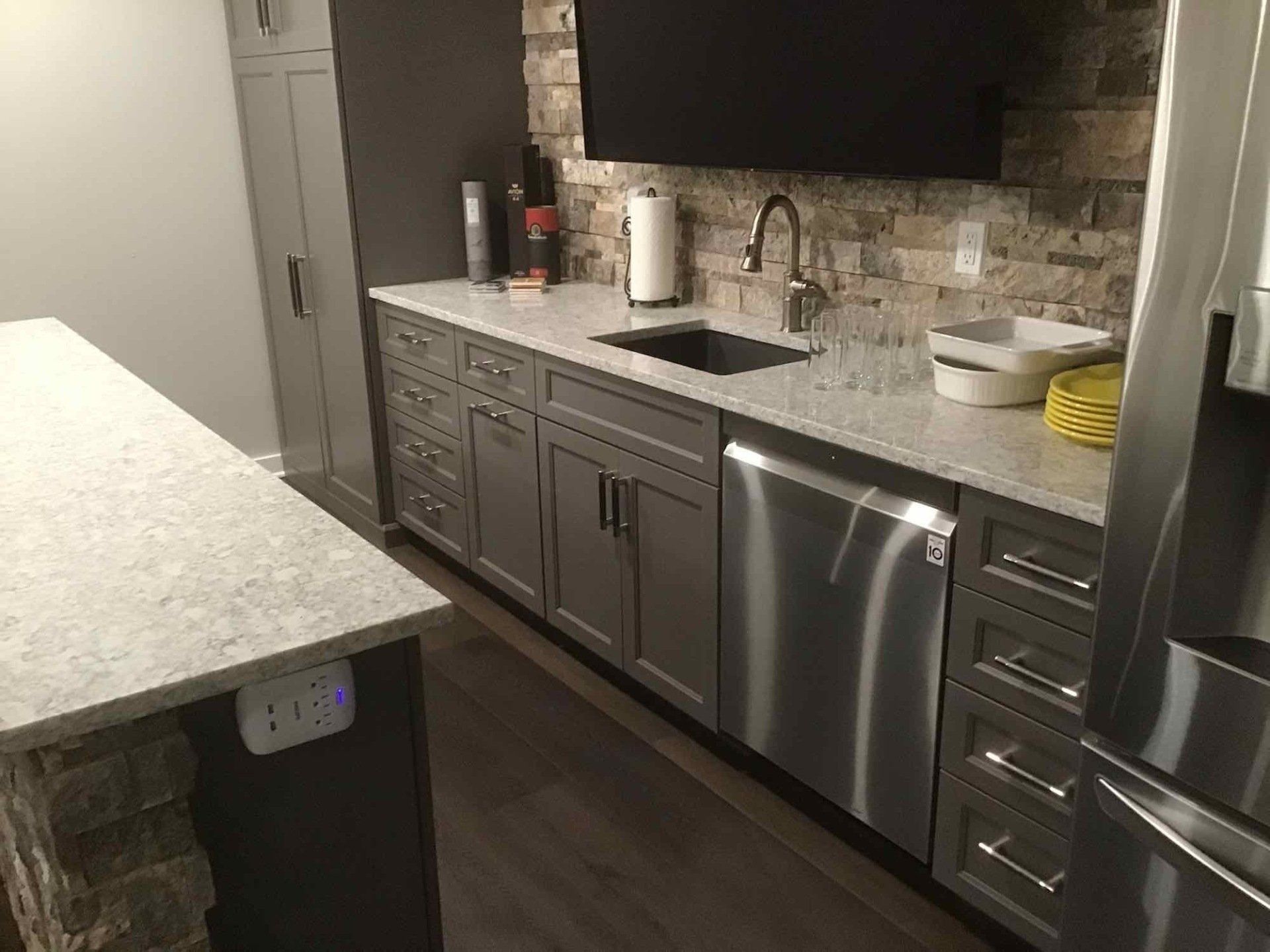 A kitchen with stainless steel appliances and granite counter tops.