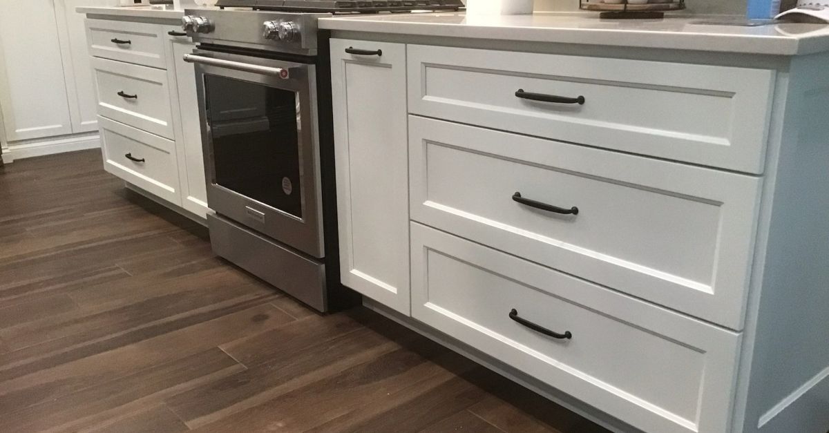 A kitchen with white cabinets and stainless steel appliances.