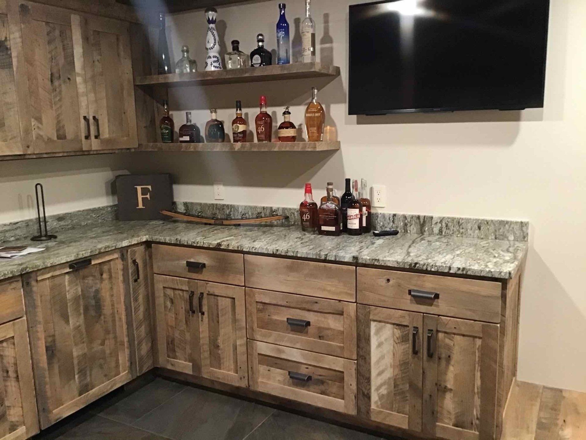 A kitchen with wooden cabinets , granite counter tops , and a flat screen tv.