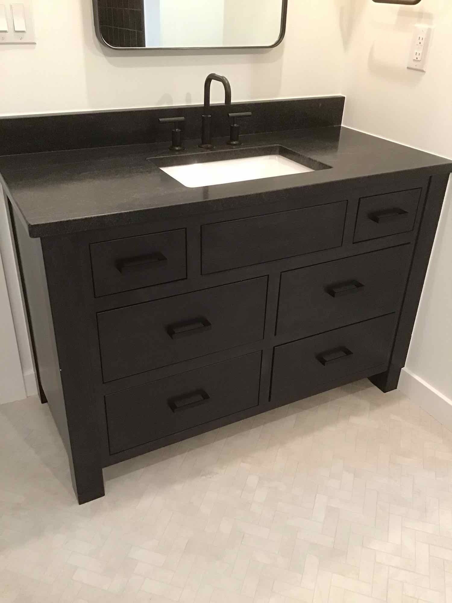A bathroom vanity with a sink and a mirror.
