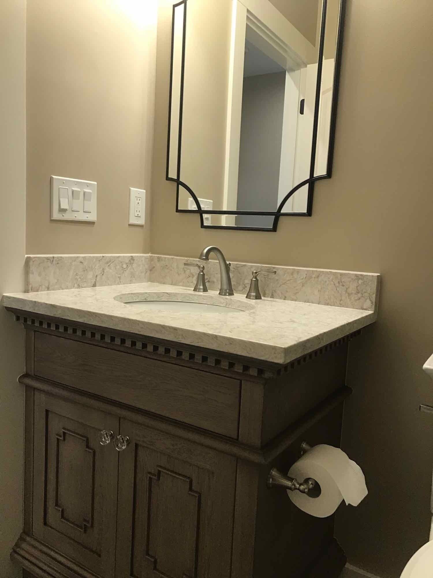 A bathroom with a sink, mirror, and toilet.