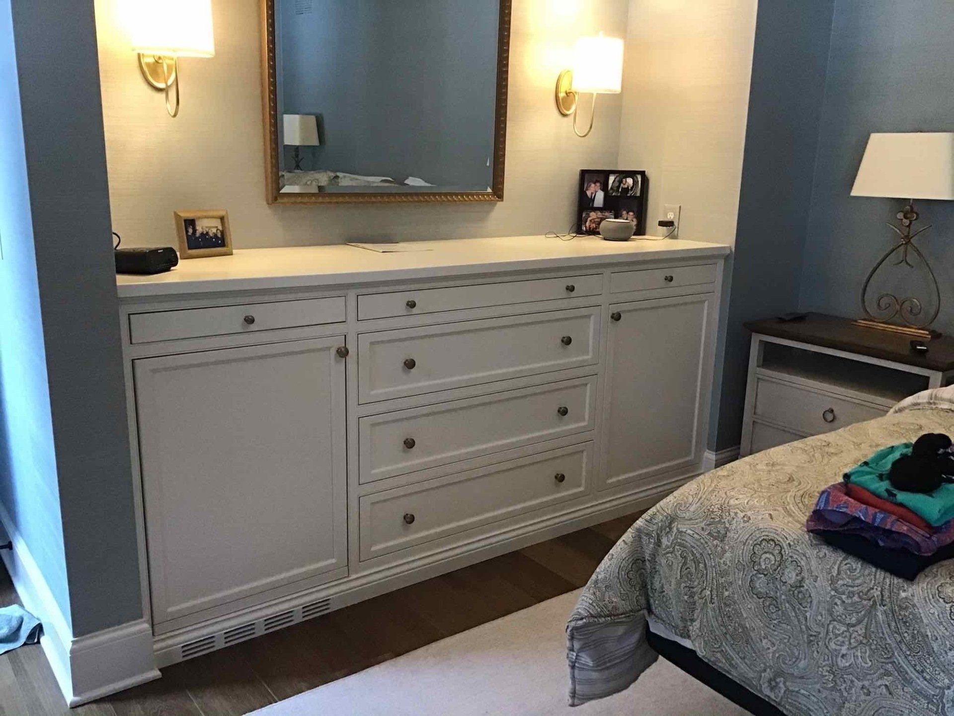 A bedroom with a bed, dresser, mirror, and nightstand.