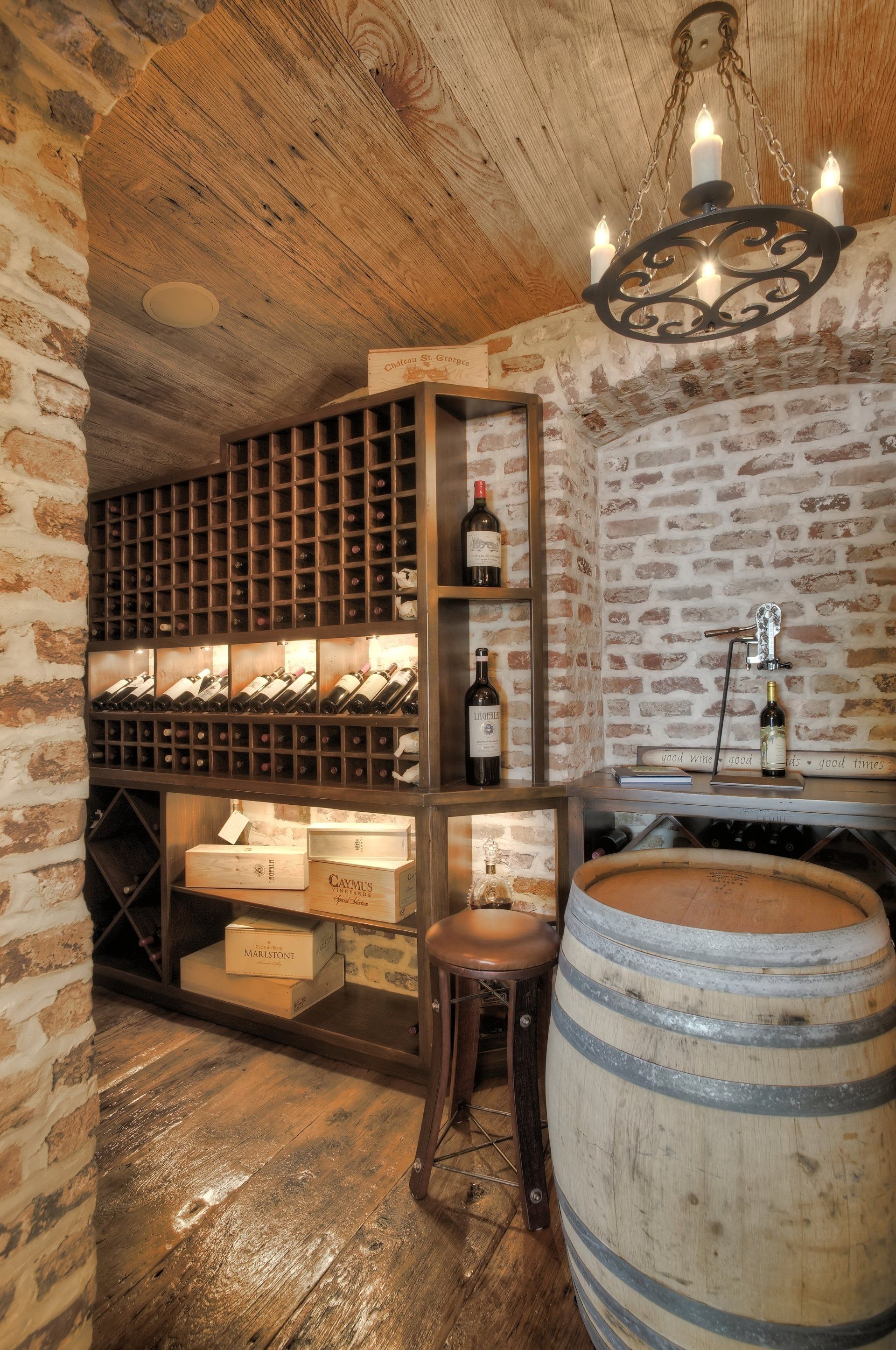 A wine cellar with a wooden barrel and a chandelier.