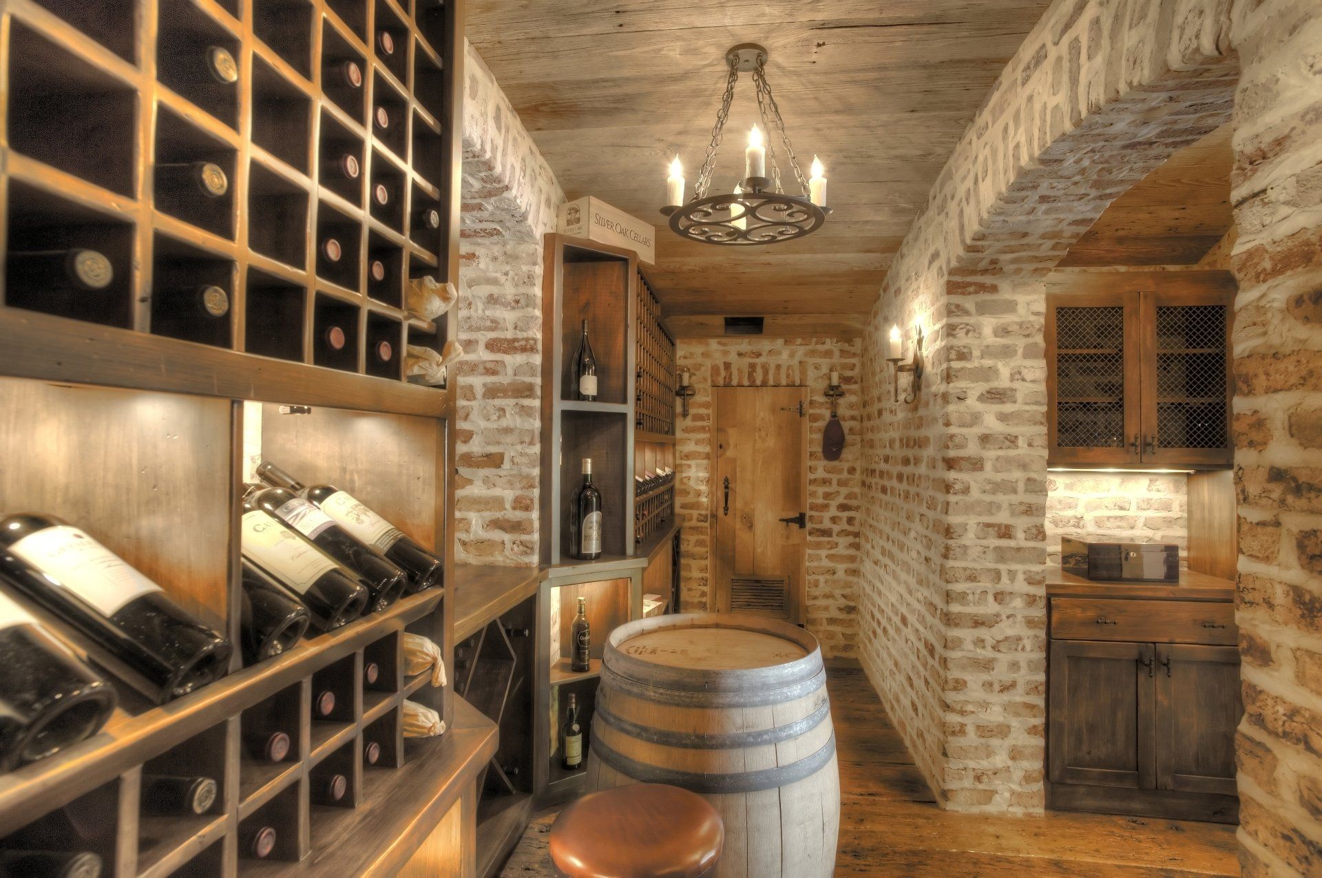 A wine cellar with bottles of wine and a wooden barrel