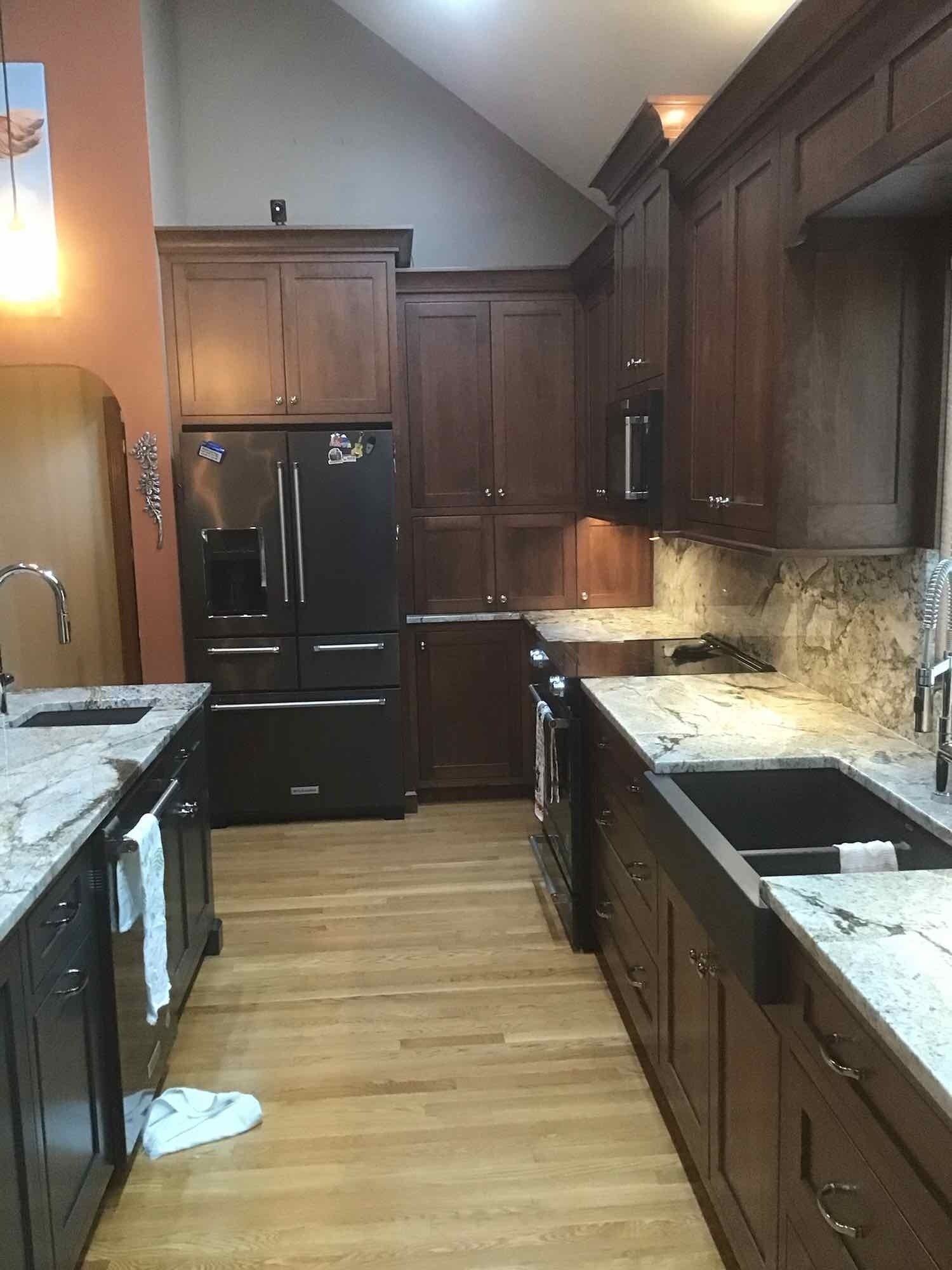 A kitchen with stainless steel appliances and wooden cabinets.