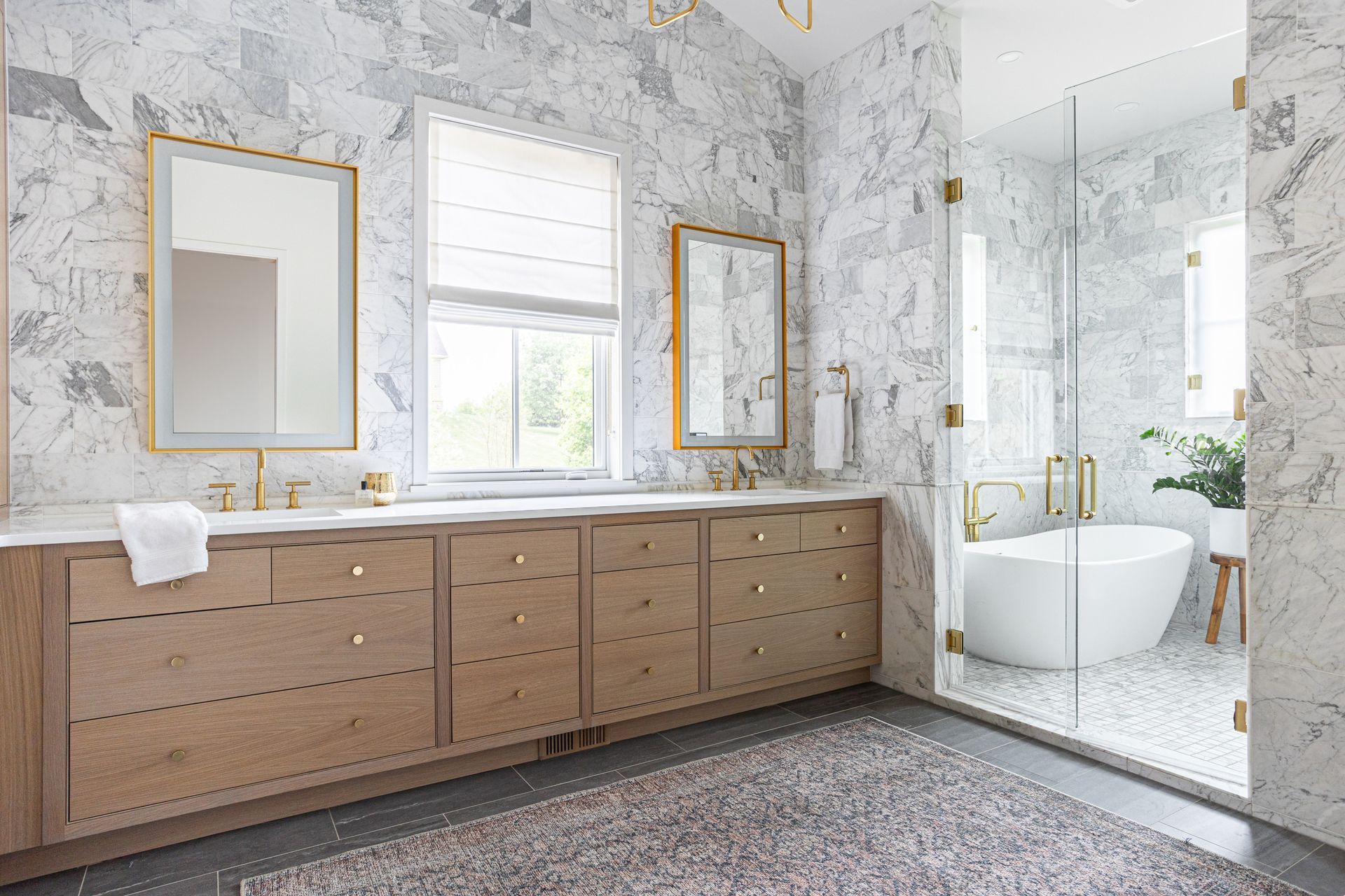 A bathroom with two sinks , two mirrors and a bathtub.