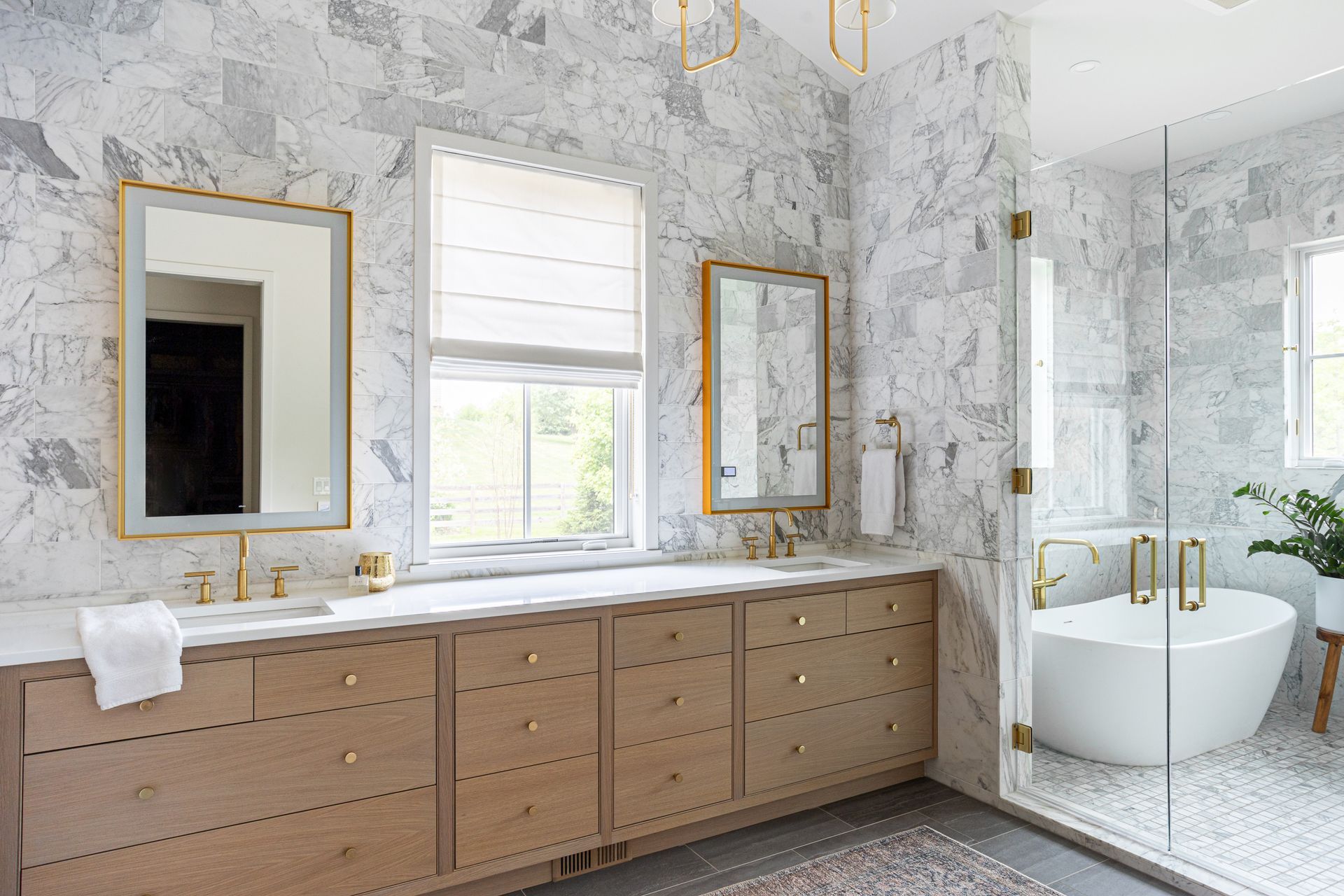 A bathroom with two sinks, two mirrors, a tub, and a walk in shower.