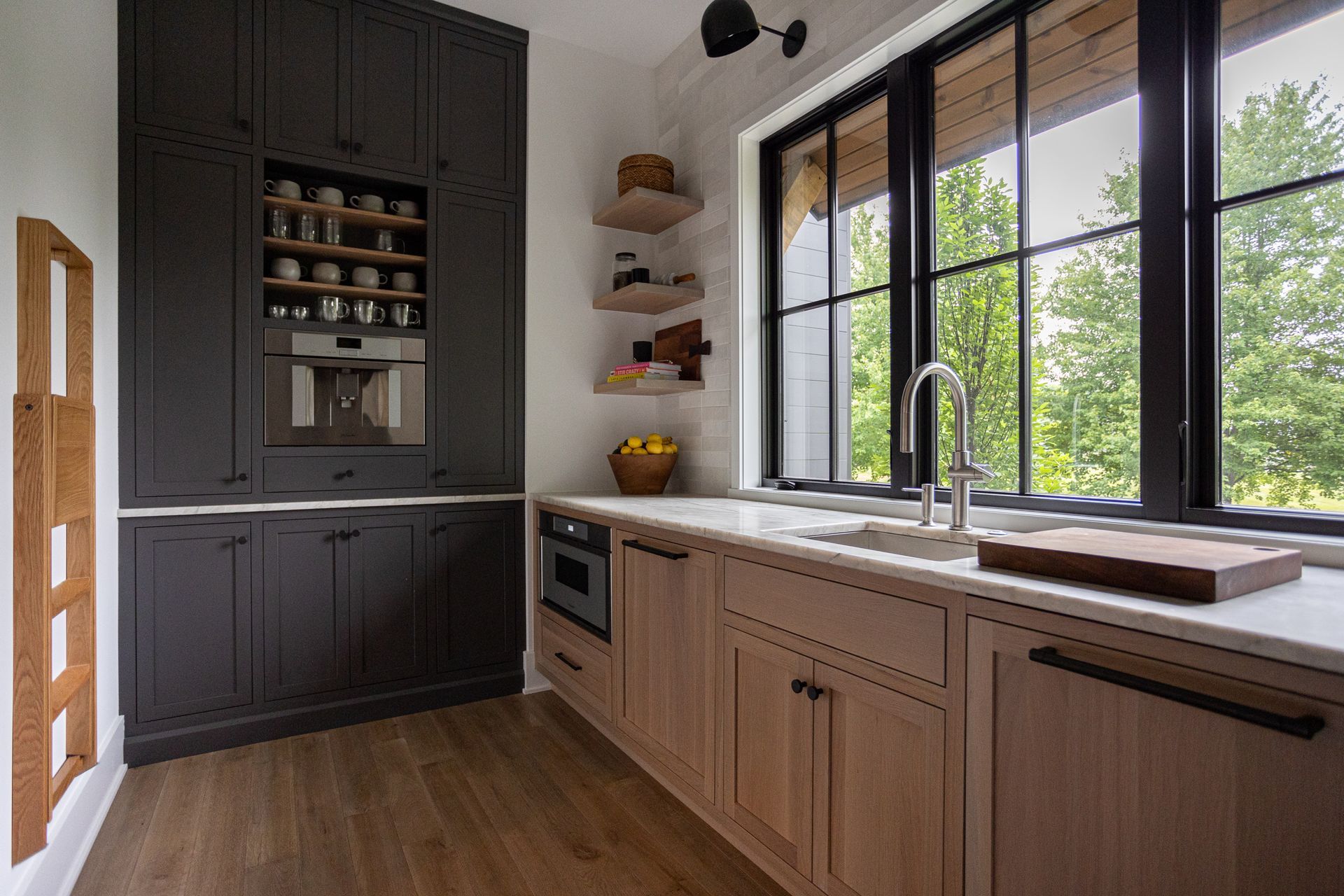 A kitchen with wooden cabinets, a sink, and a large window.