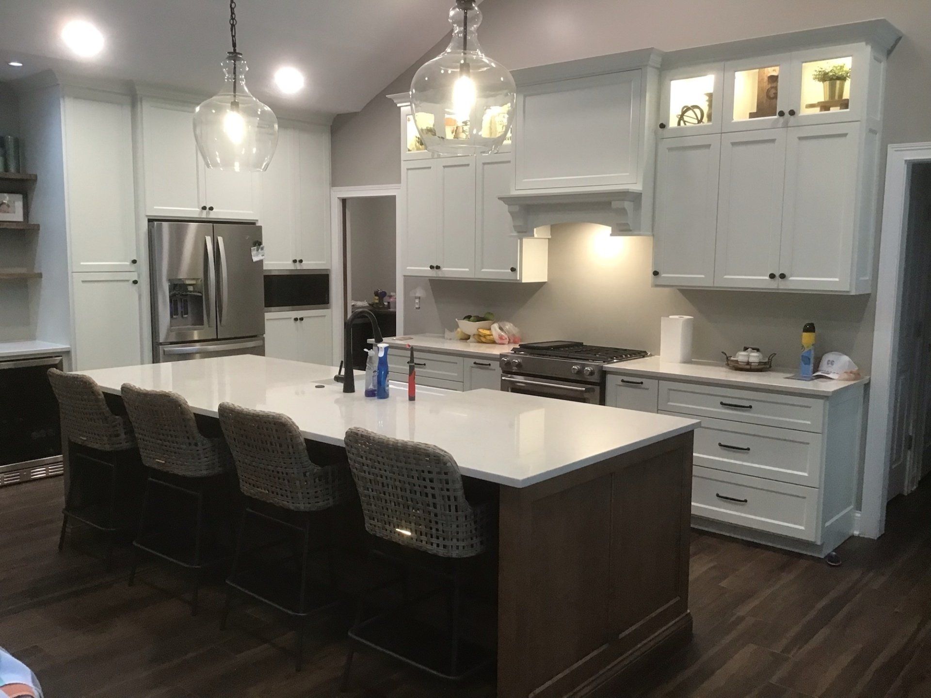 A kitchen with white cabinets , stainless steel appliances , and a large island.