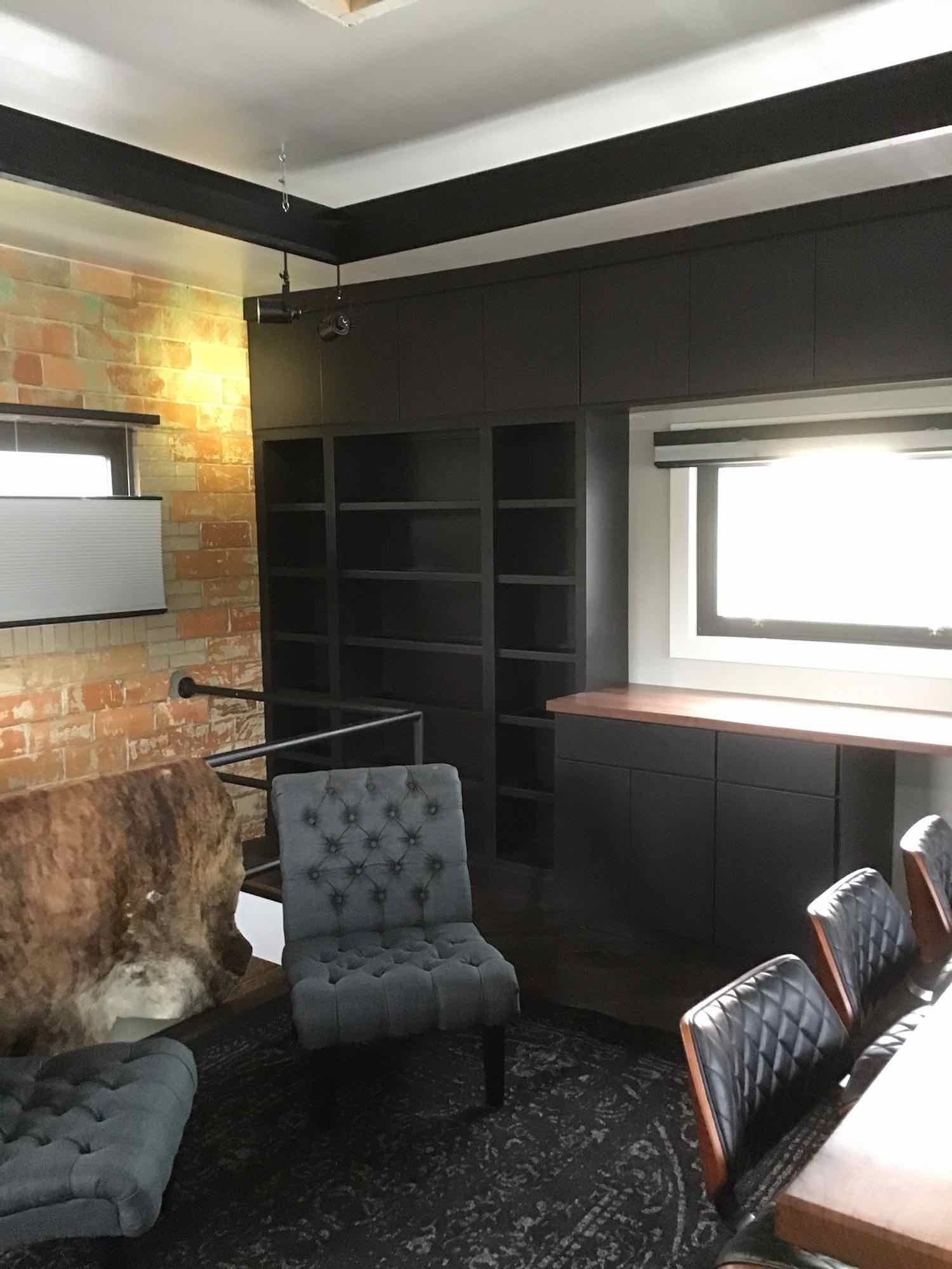 A living room with a couch, chairs, a table and a window.