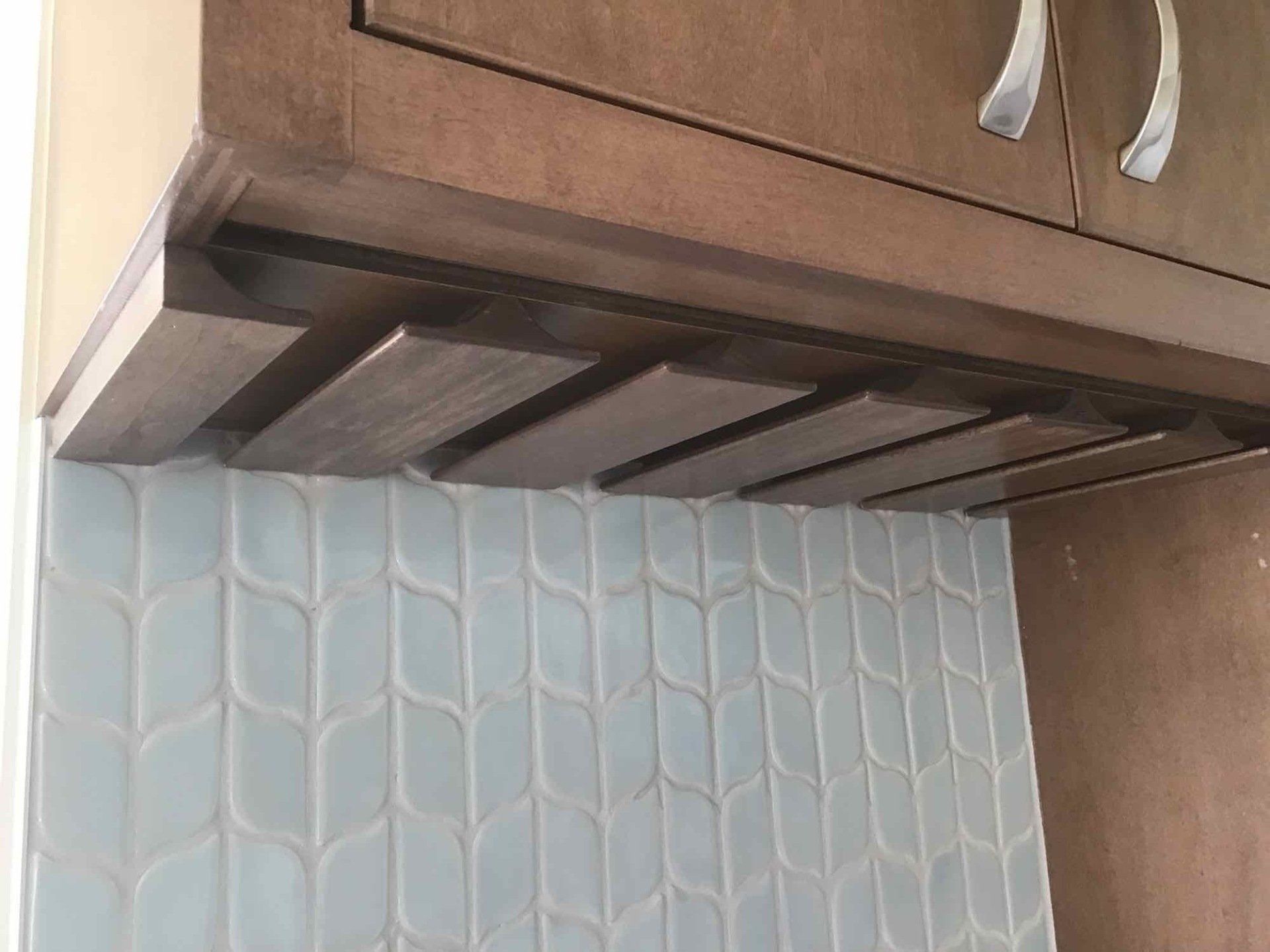 A kitchen with a hood and a tile wall.