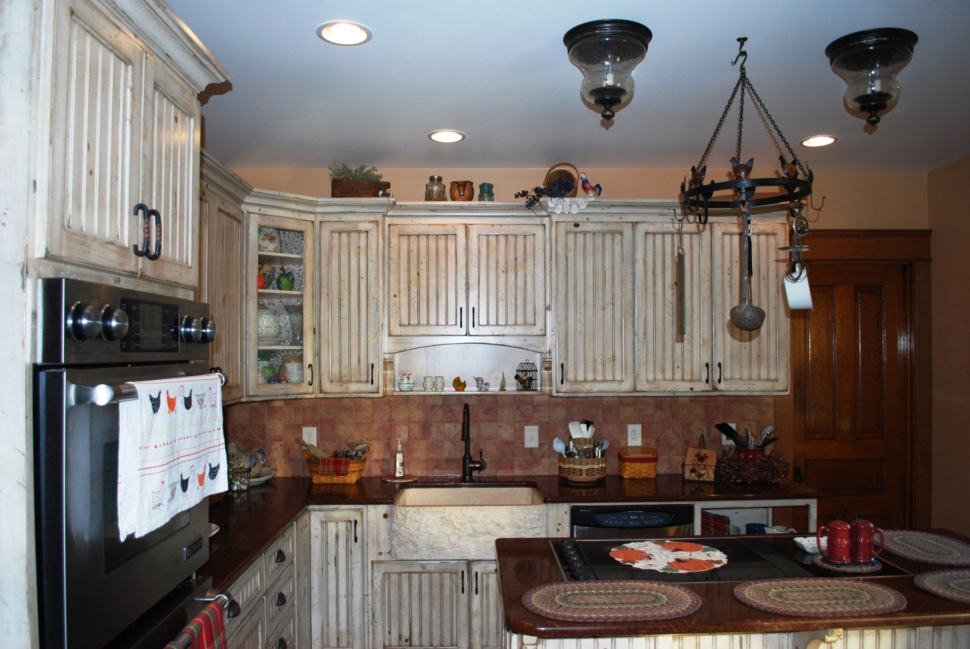 A kitchen with white cabinets and black appliances.