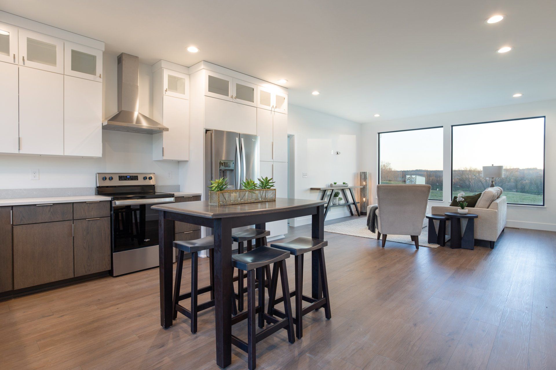 A kitchen with a table and stools in it.