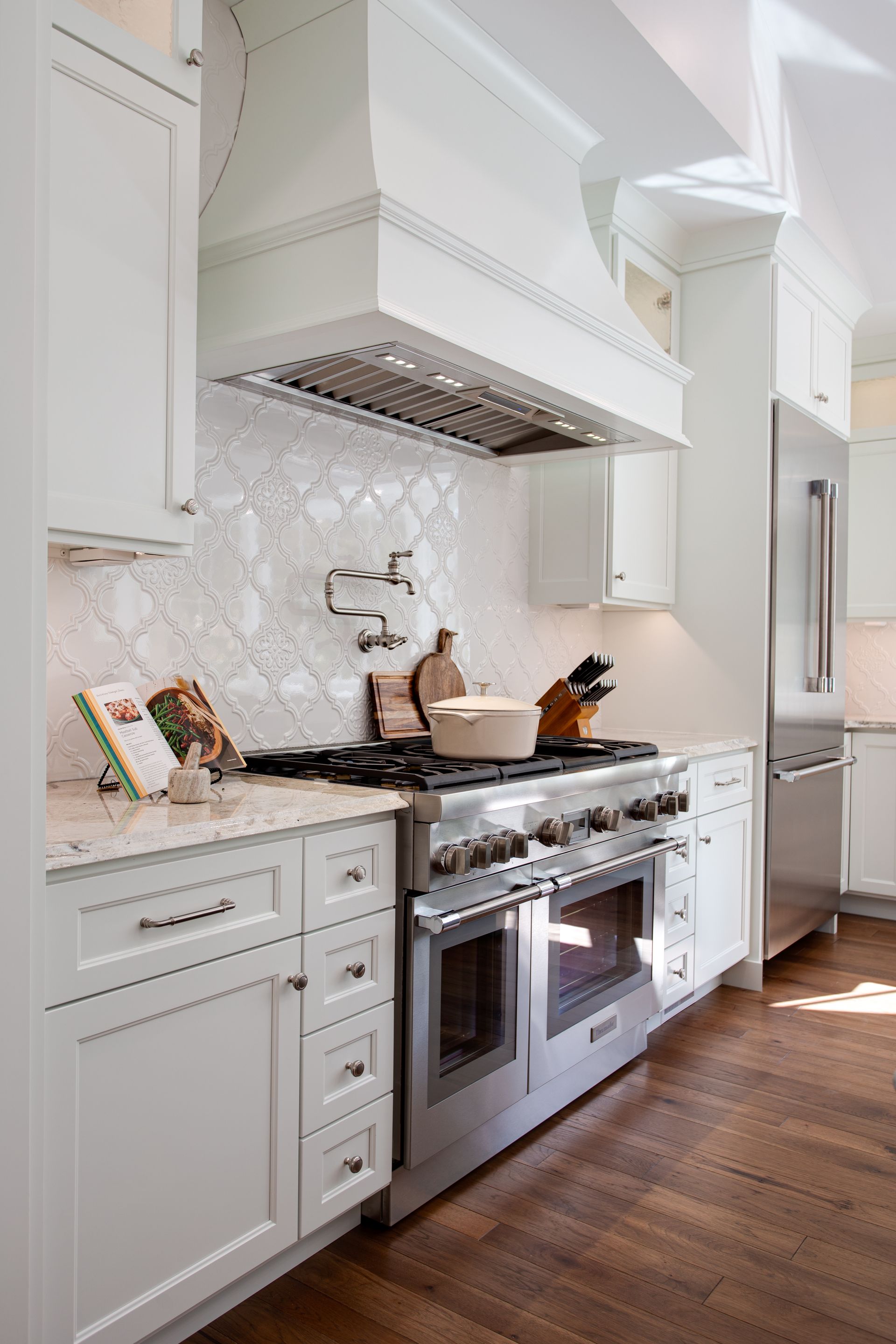 A kitchen with stainless steel appliances and white cabinets.