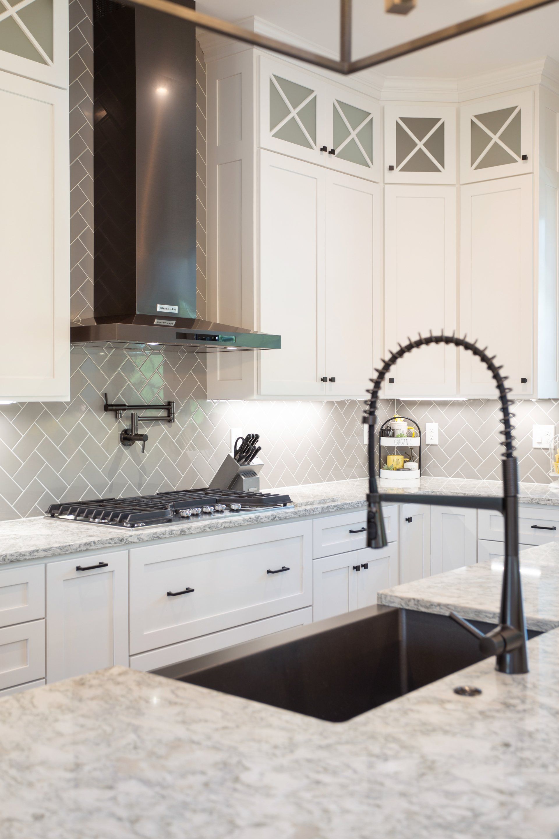 A kitchen with white cabinets and a black sink.