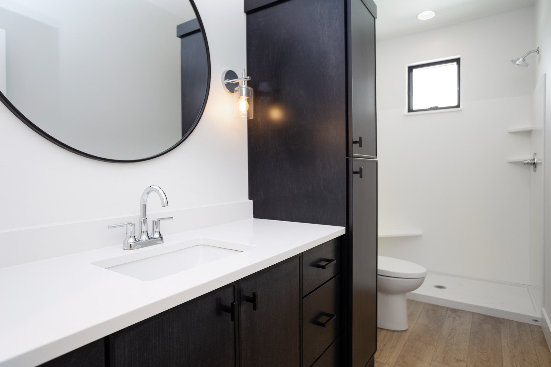 A bathroom with a sink a toilet and a mirror.