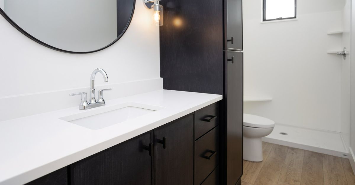 A bathroom with a sink , toilet and mirror.