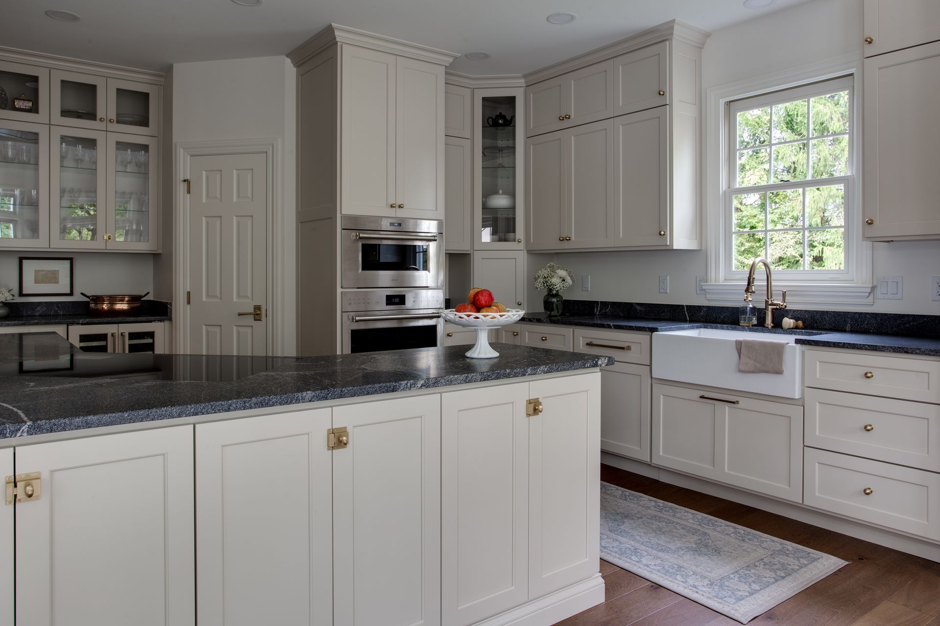 A kitchen with white cabinets and black counter tops
