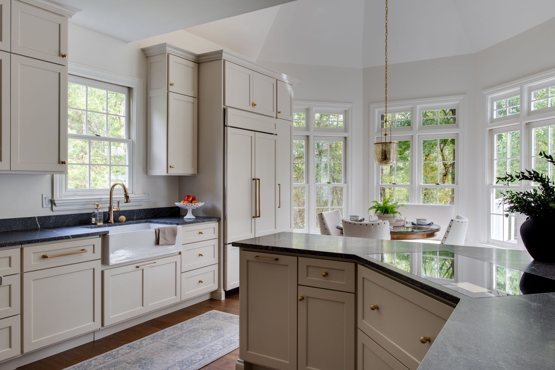 A kitchen with white cabinets and black counter tops