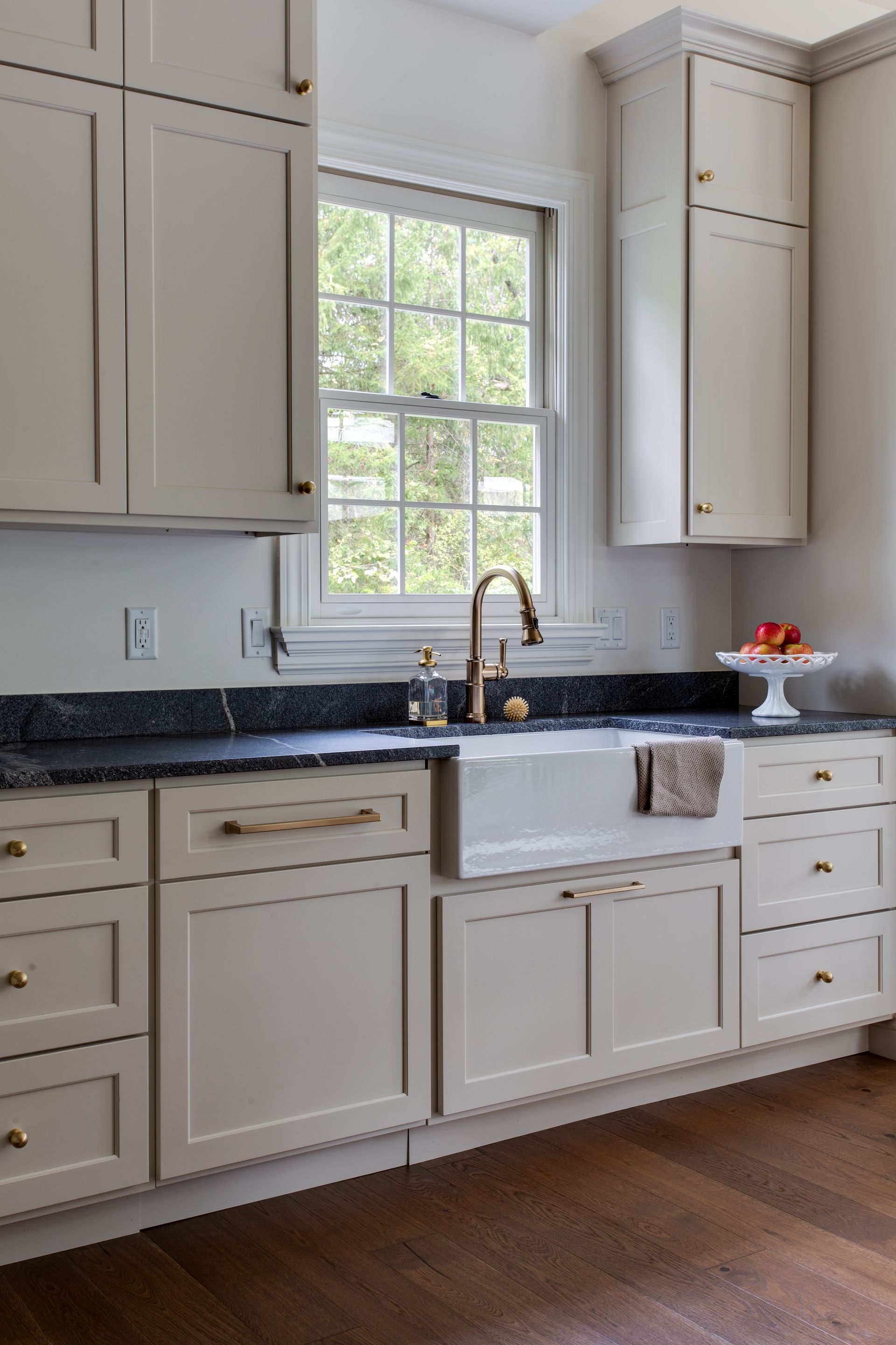 A kitchen with white cabinets a sink and a window