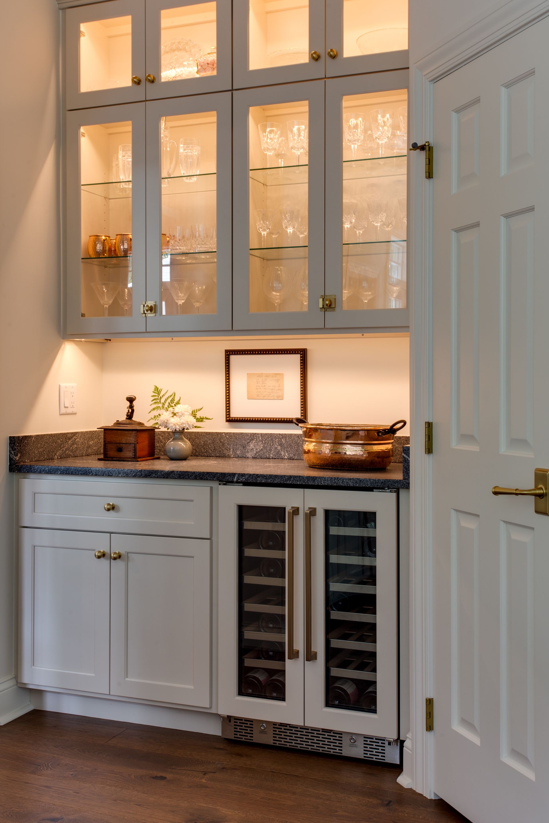A kitchen with white cabinets and a wine cooler