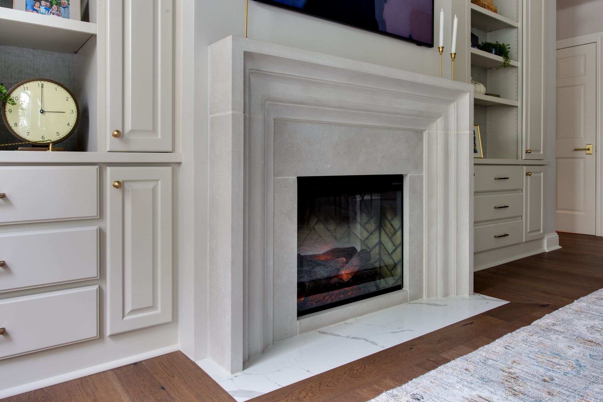 A living room with a fireplace and a clock on the wall.