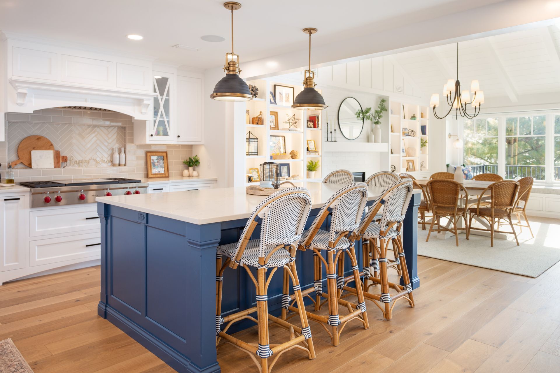 A kitchen with a blue island and wicker bar stools.