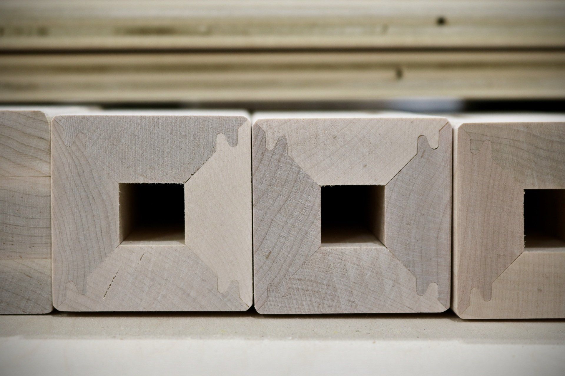 A row of wooden blocks with square holes in them.