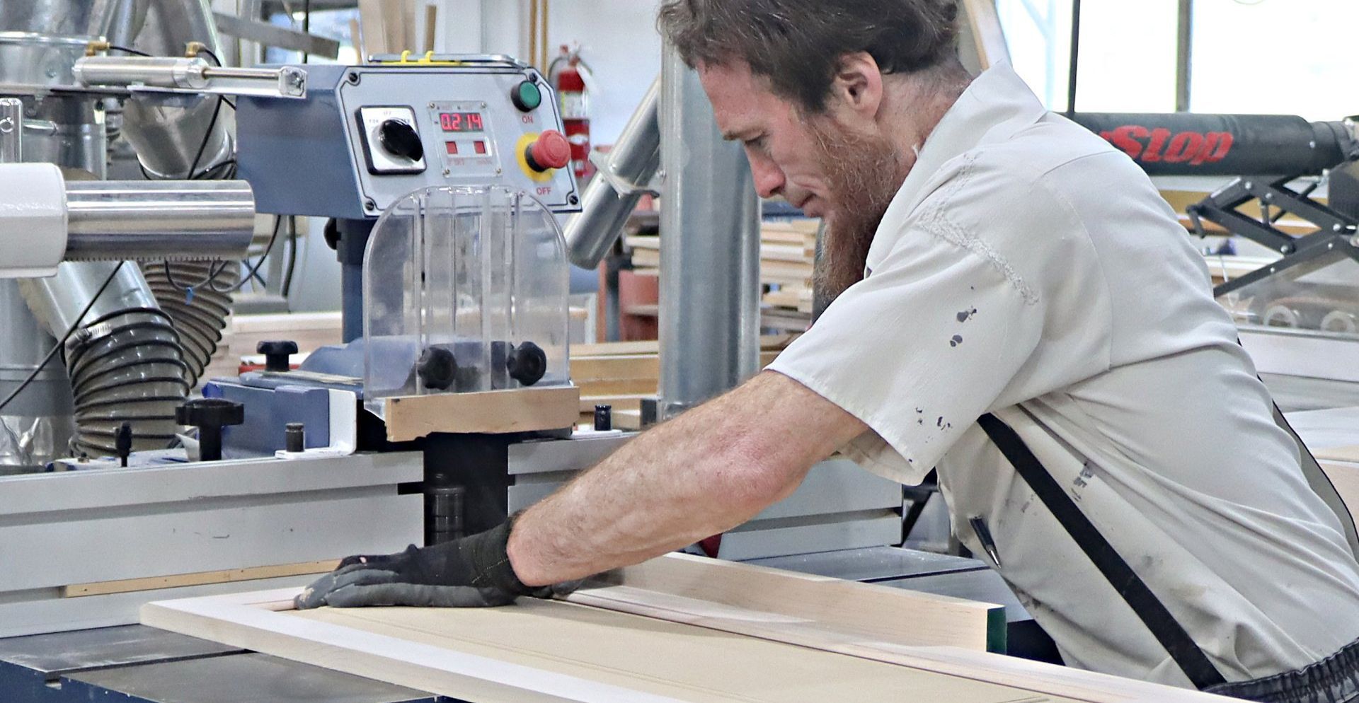 A man is working on a piece of wood in a factory.