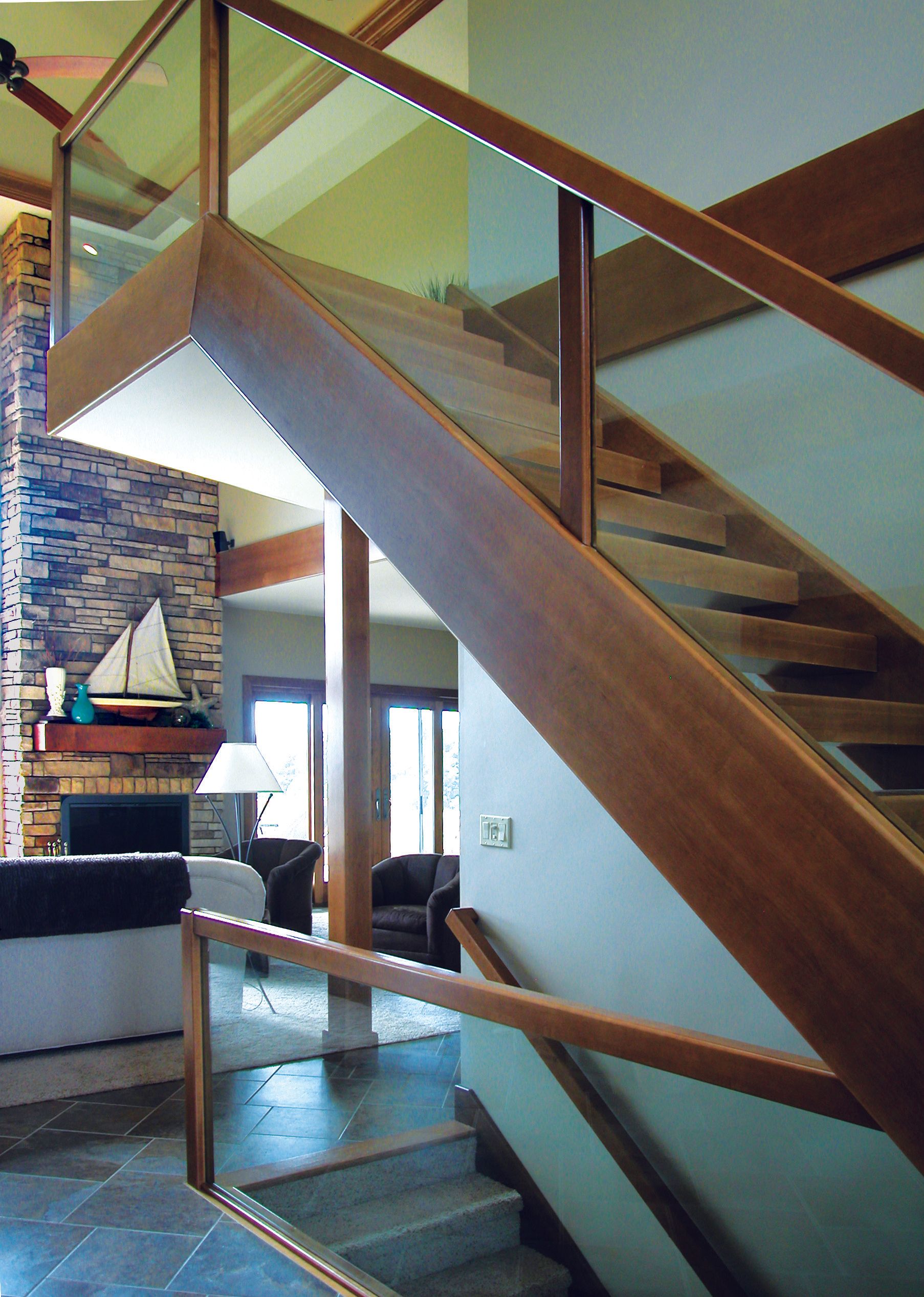 A wooden staircase with a glass railing in a living room
