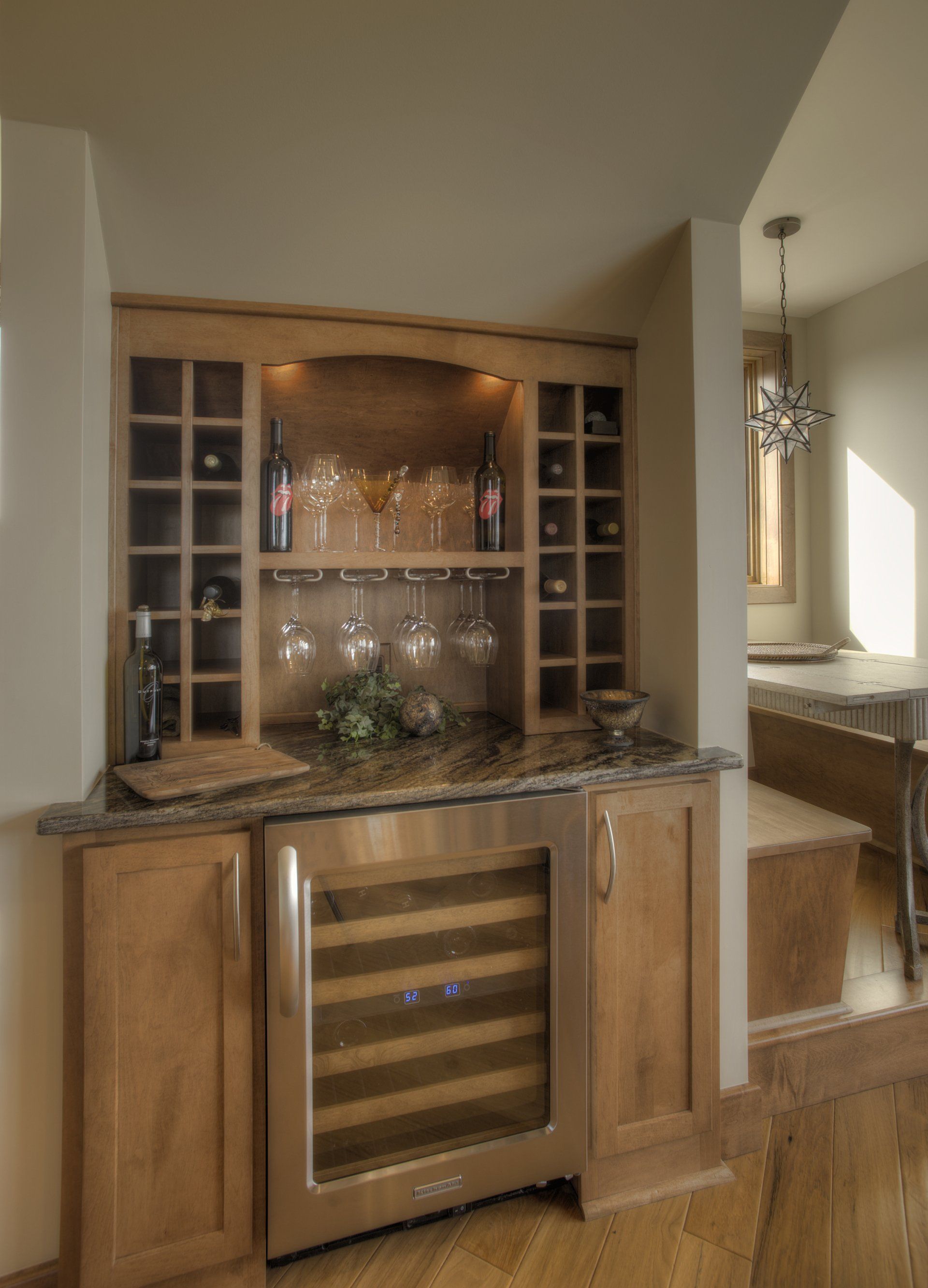 A kitchen with a wine cooler and a wine rack.
