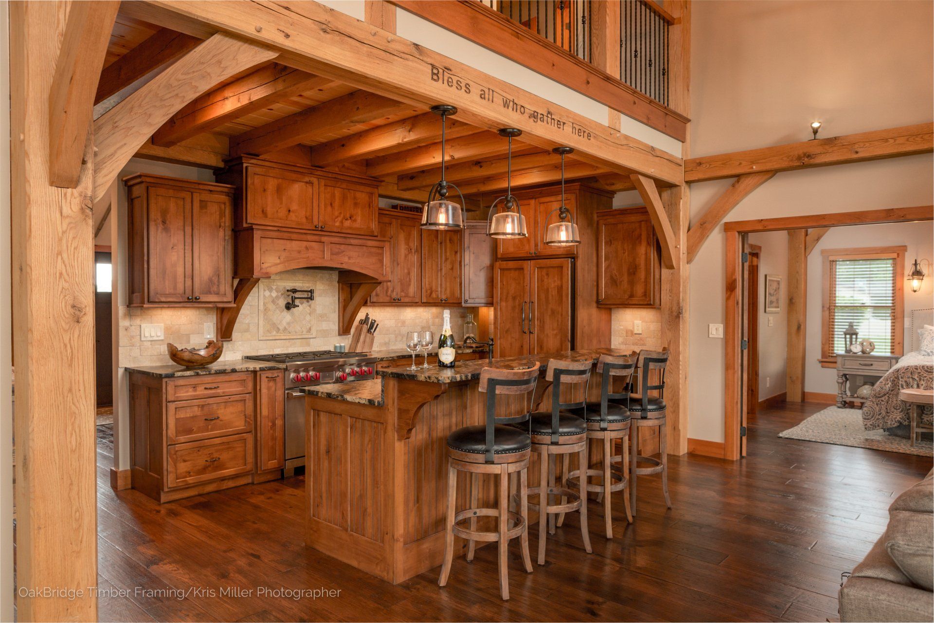 A kitchen in a log cabin with wooden cabinets and stools.