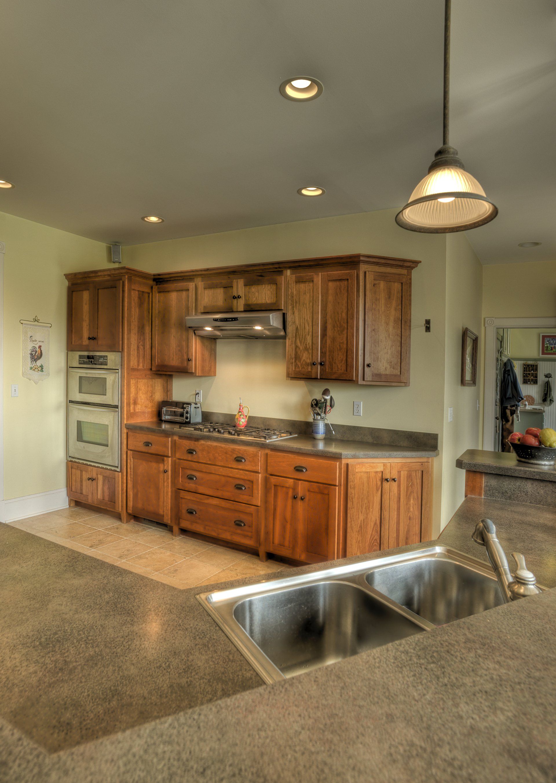 A kitchen with wooden cabinets and a stainless steel sink.