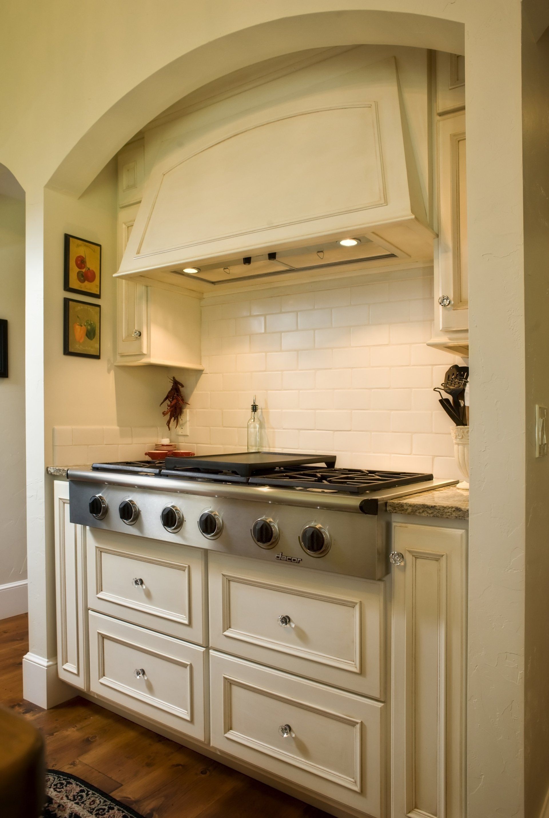 A kitchen with white cabinets and a stove top oven.