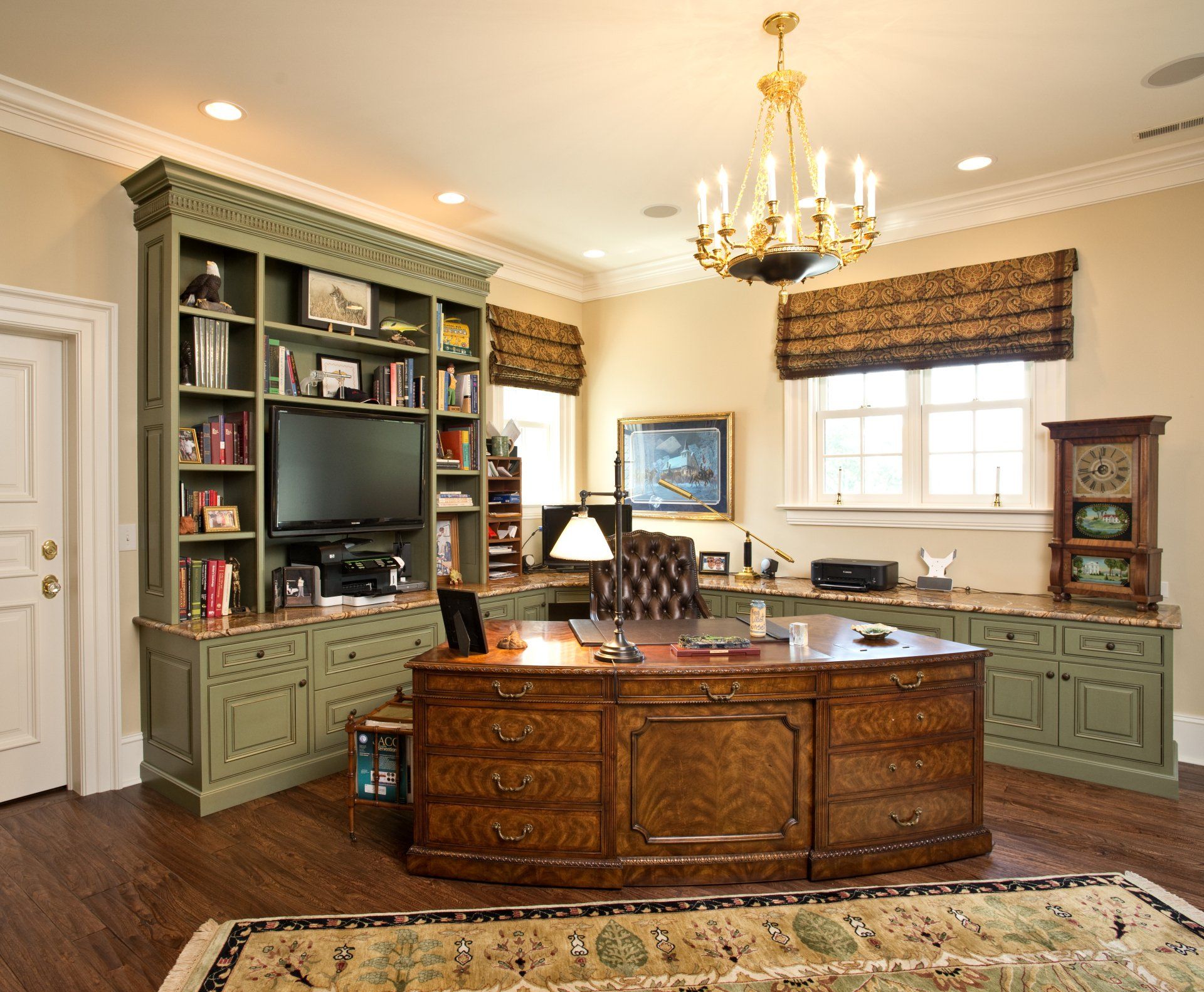 A beautiful office setting with a wooden desk surrounded by green cabinets.