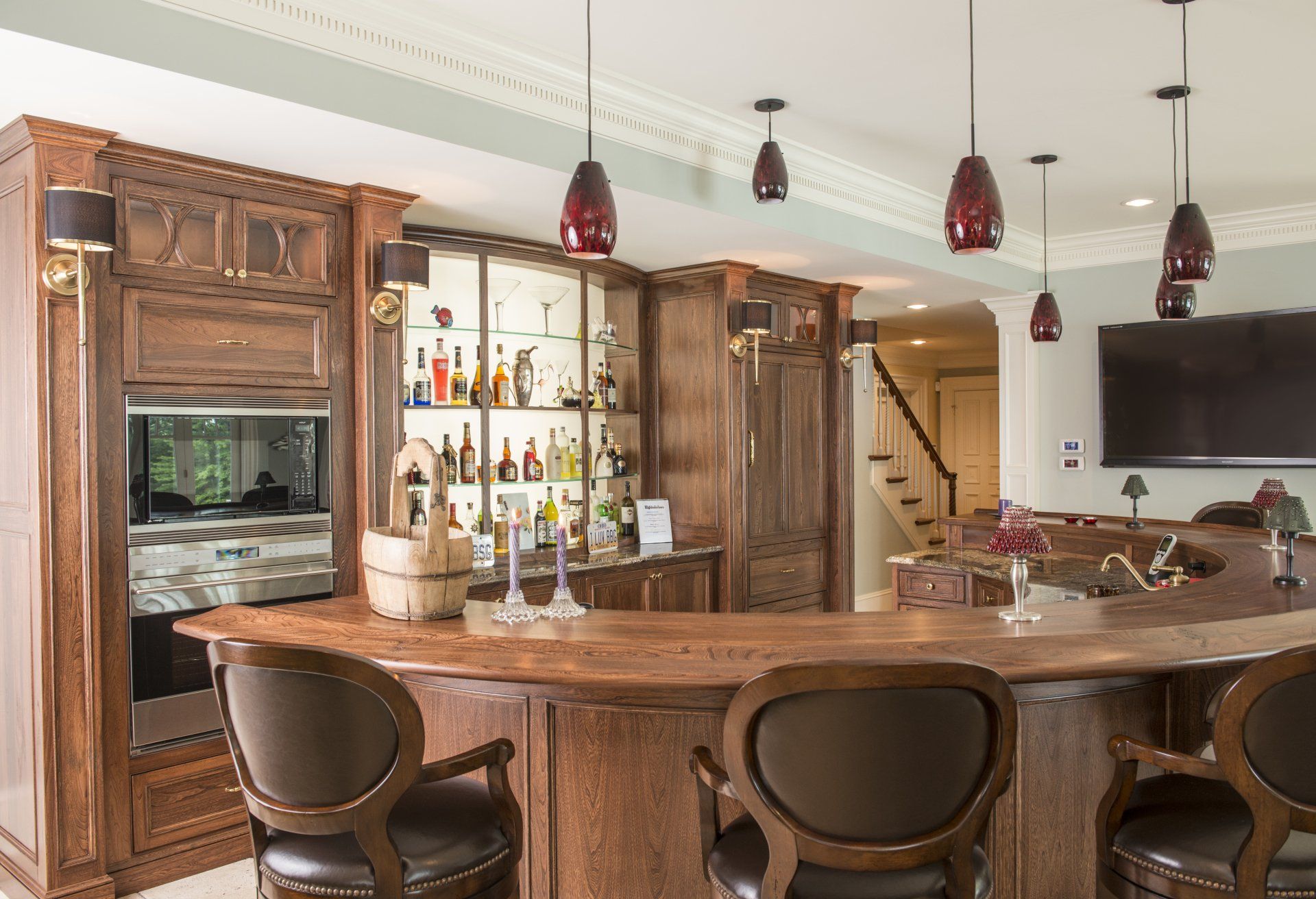 There is a beautiful custom bar with built-in cabinets in a room. 